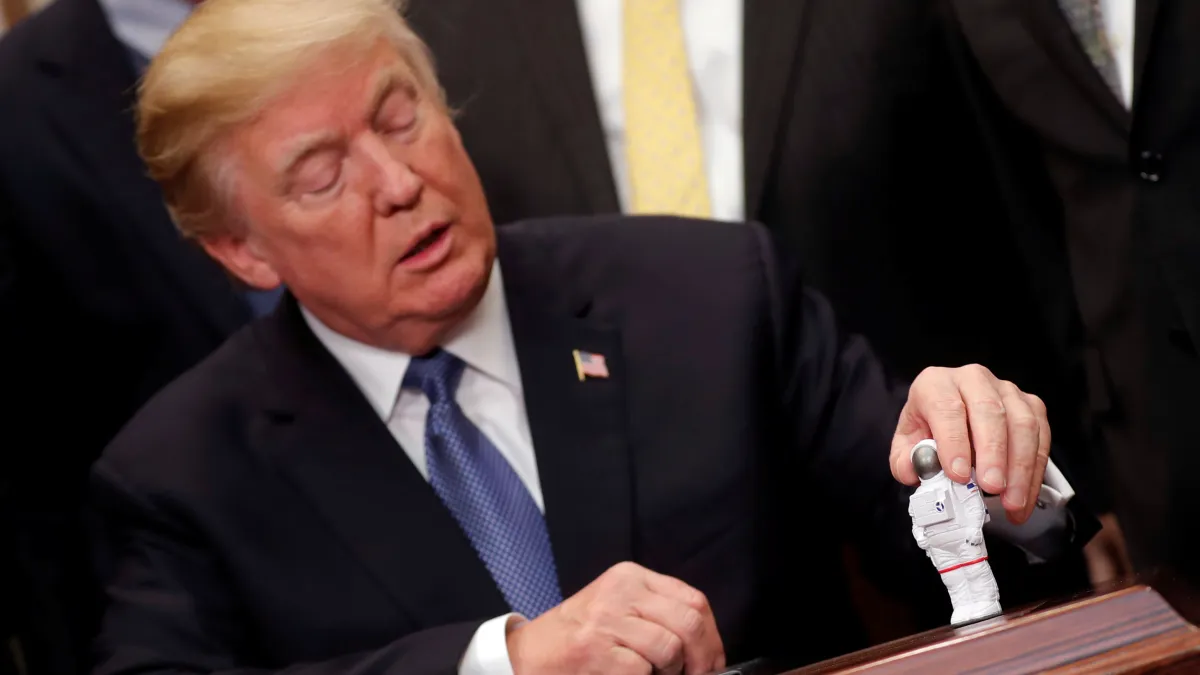 U.S. President Donald Trump holds a space astronaut toy as he participates in a signing ceremony for Space Policy Directive at the White House in Washington D.C., U.S. December 11, 2017. REUTERS/Carlos Barria U.S. President Donald Trump holds a space astronaut toy as he participates in a signing ceremony for Space Policy Directive at the White House in Washington D.C.