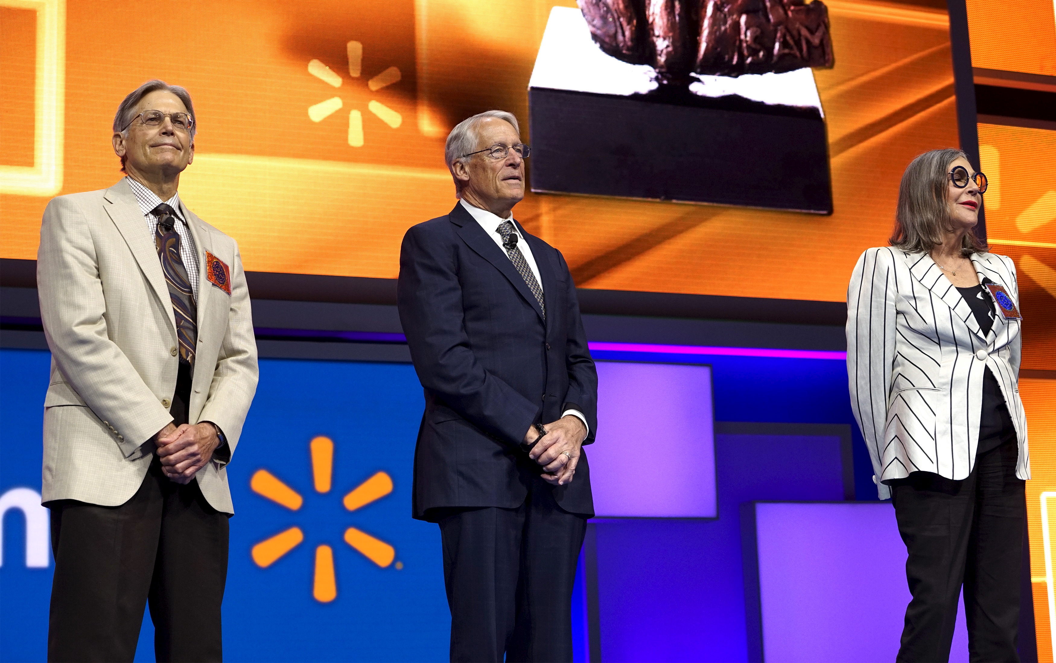 Walton family members Jim, Rob and Alice Walton speak onstage at the Wal-Mart annual meeting in Fayetteville