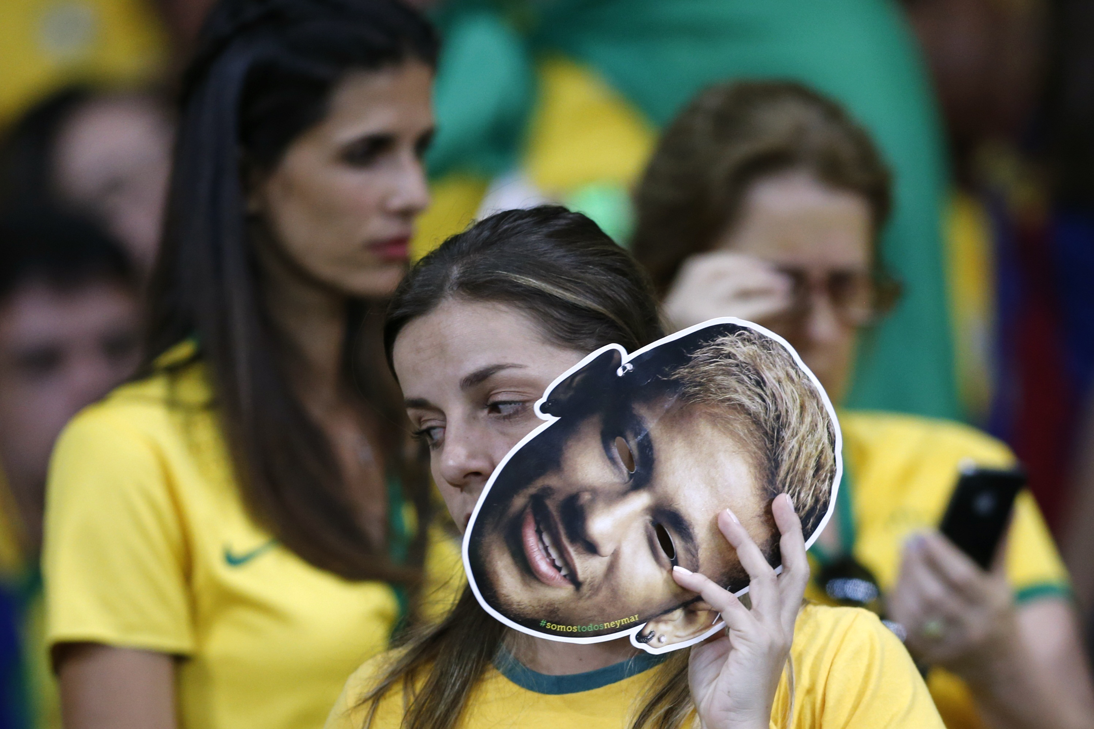 A fan holds mask of Brazil's Neymar during the 2014 World Cup semi-finals between Brazil and Germany at the Mineirao stadium