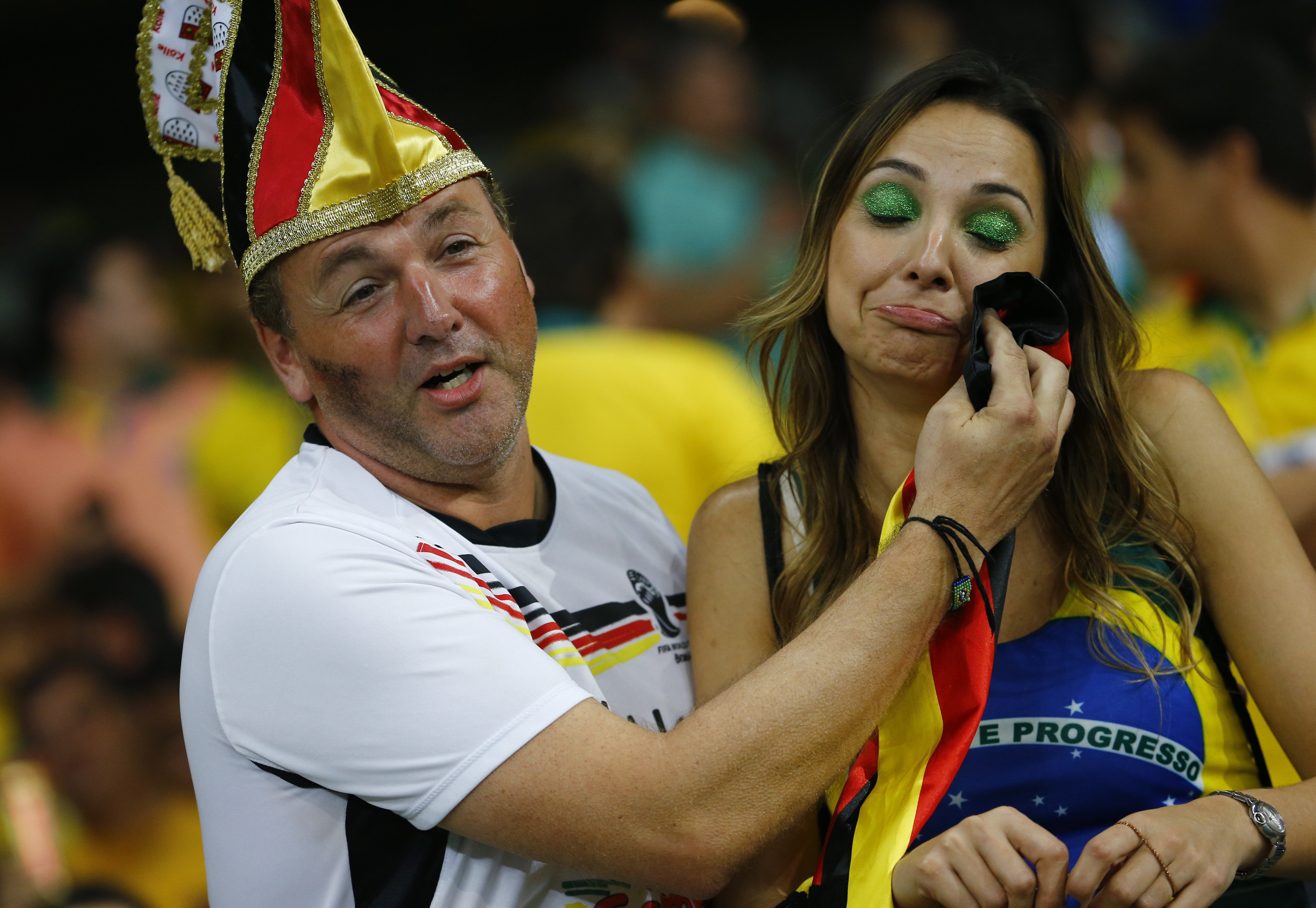 A Germany fan consoles a Brazil fan during their 2014 World Cup semi-finals at the Mineirao stadium in Belo Horizonte 