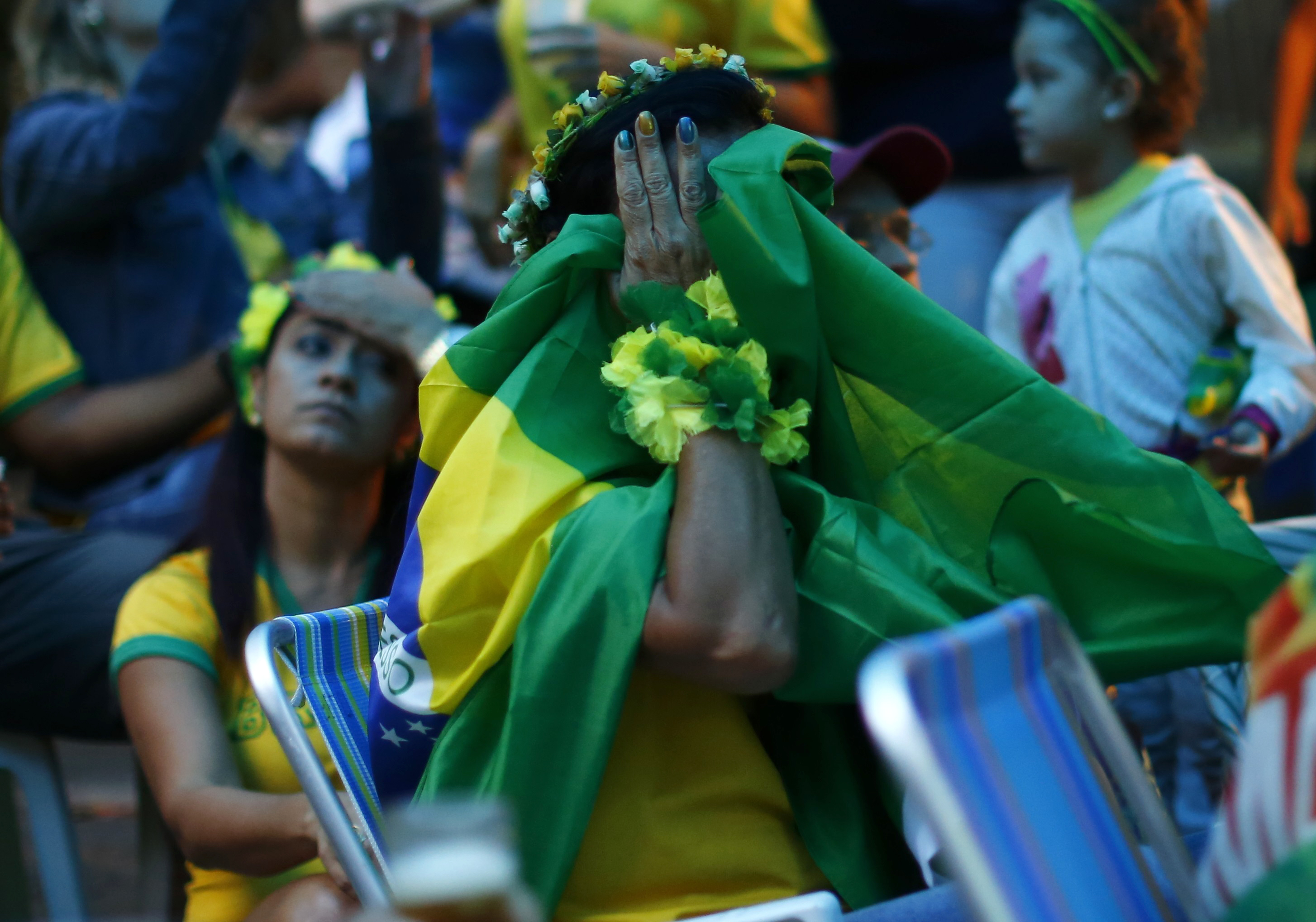 Brazil fans react as they watch their 2014 World Cup semi-finals against Germany on a street in Rio de Janeiro