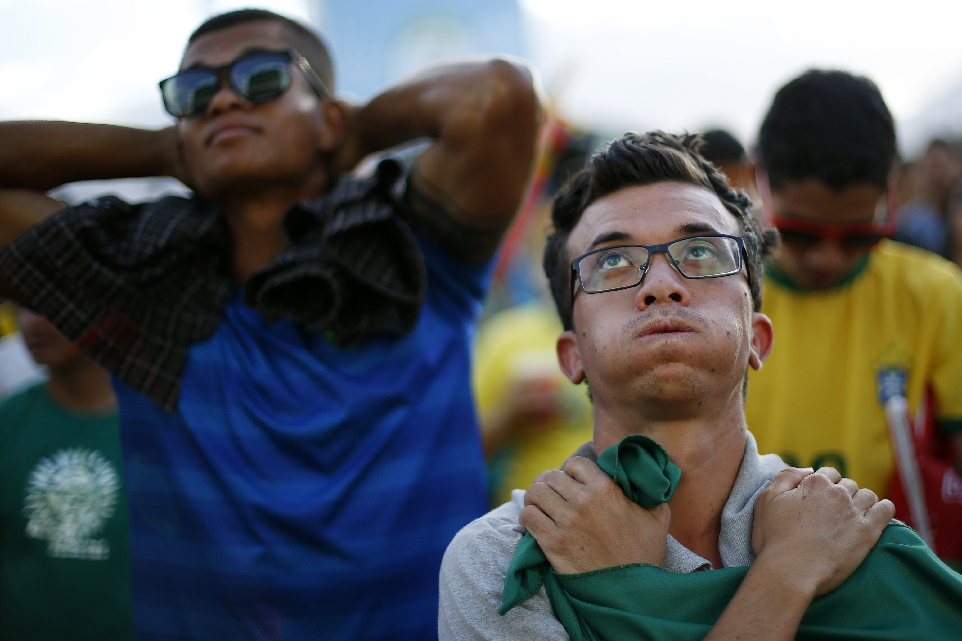 Fans of Brazil react while watching a broadcast of the 2014 World Cup semi-final against Germany at the Fan Fest in Brasilia