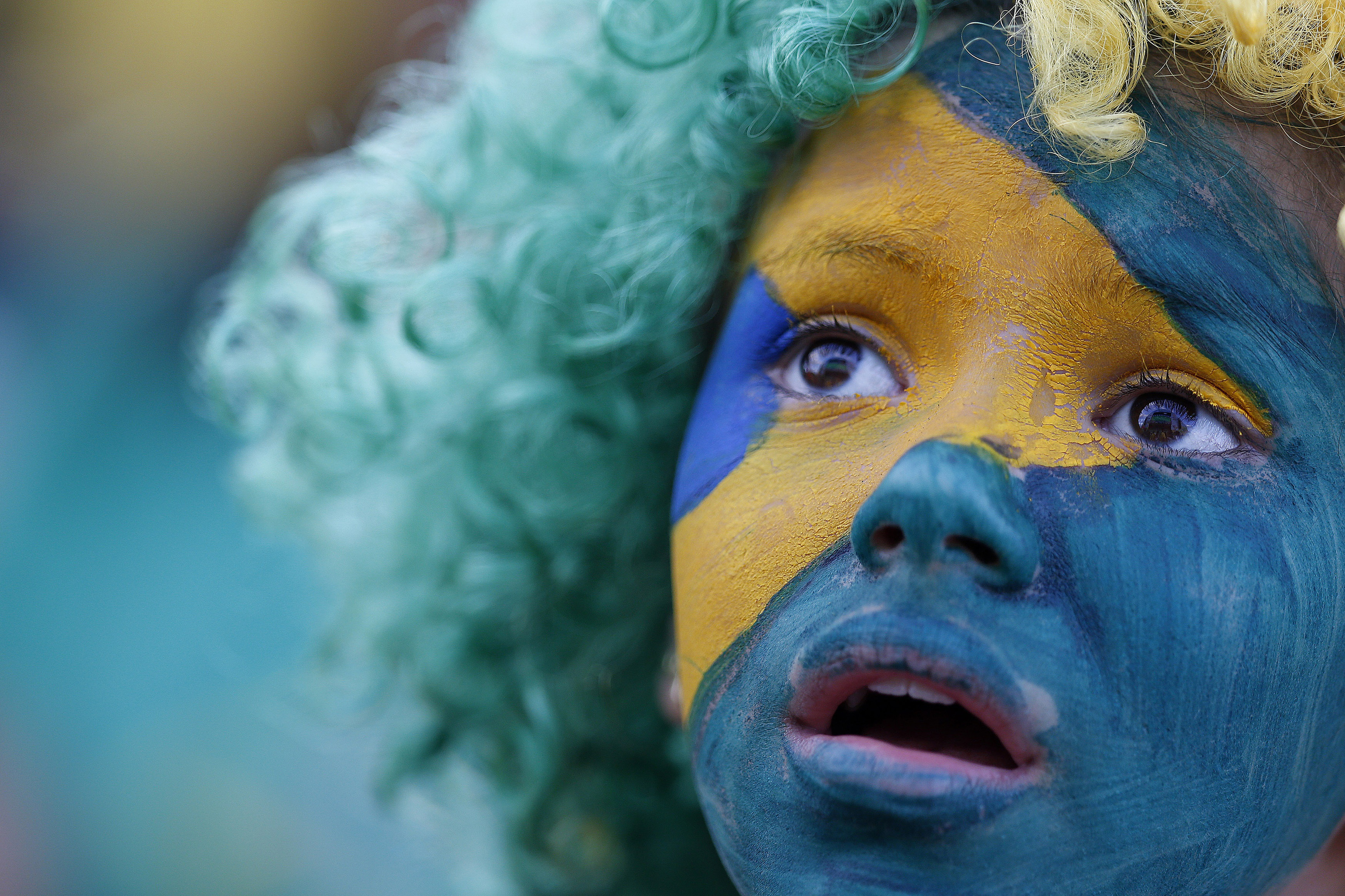 A fan of Brazil reacts while watching a broadcast of the 2014 World Cup semi-final against Germany at the Fan Fest in Brasilia