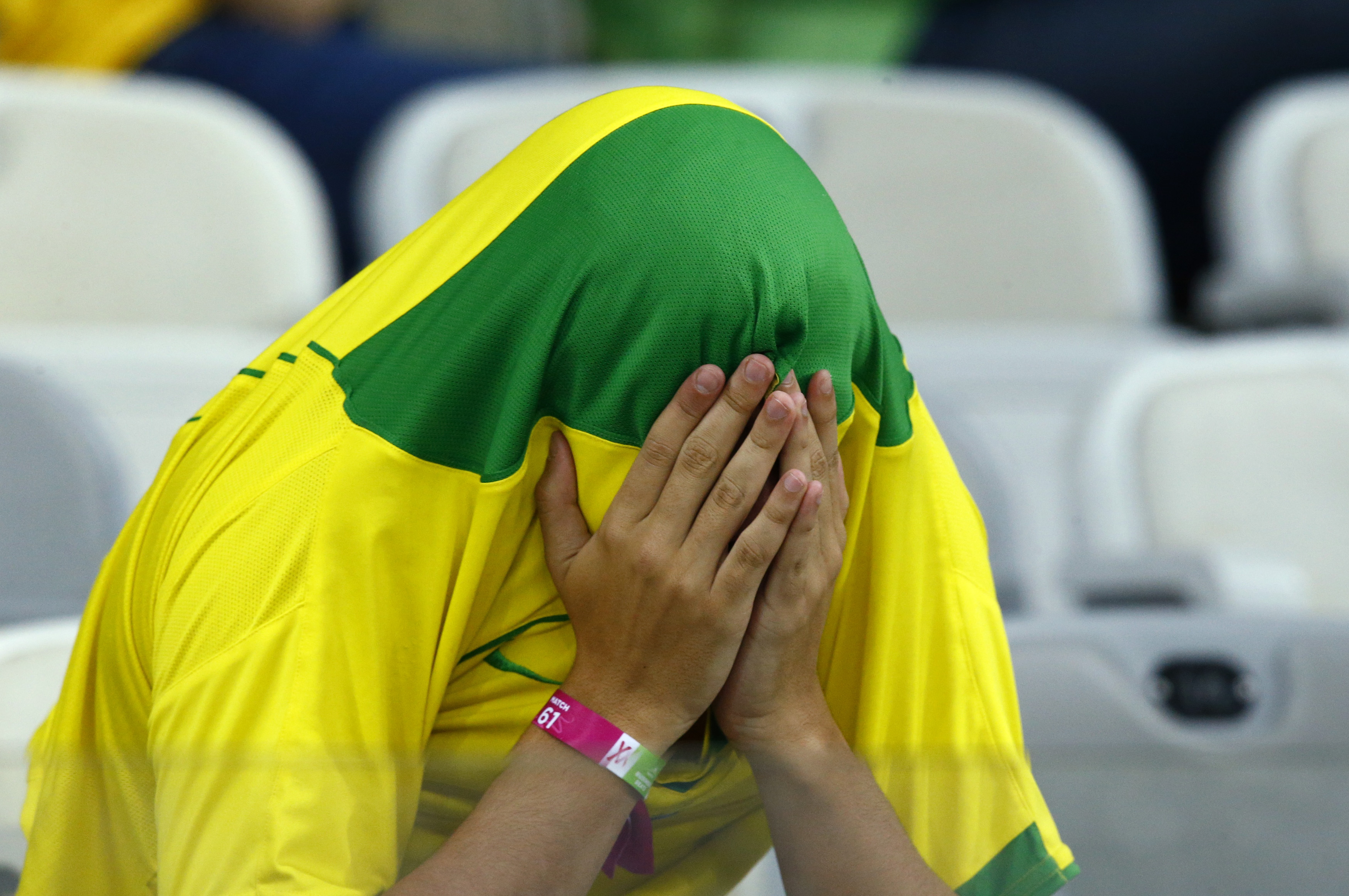 A Brazil fan covers his face after the team's 2014 World Cup semi-finals against Germany at the Mineirao stadium in Belo Horizonte