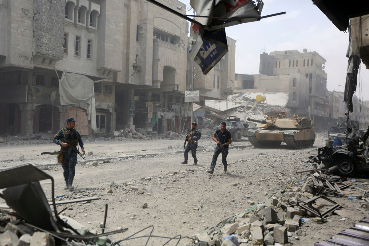 Members of Iraqi federal police run with their weapons during fighting with Islamic State militants at the frontline in the Old City of Mosul