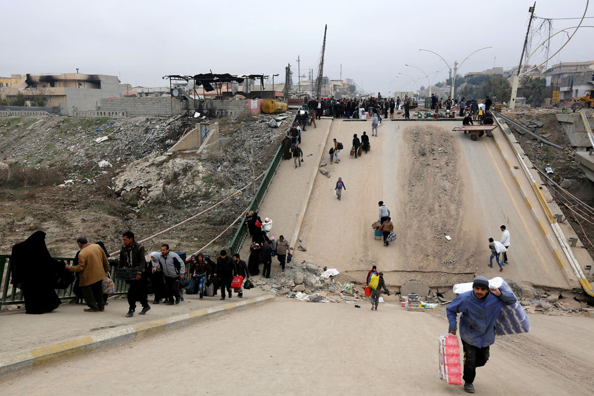 Displaced people, who fled Islamic State militants, cross the bridge in Al-Muthanna neighborhood of Mosul