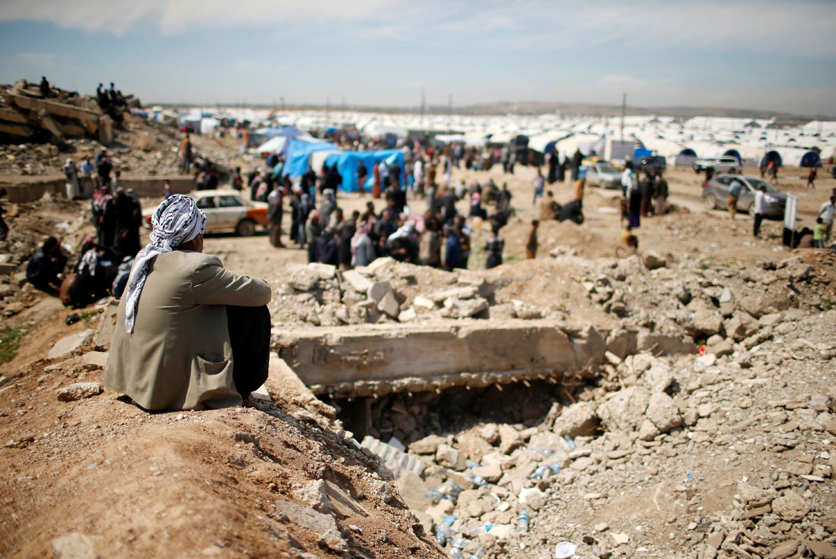 Displaced Iraqis who had fled their homes wait outside Hammam al-Alil camp south of Mosul