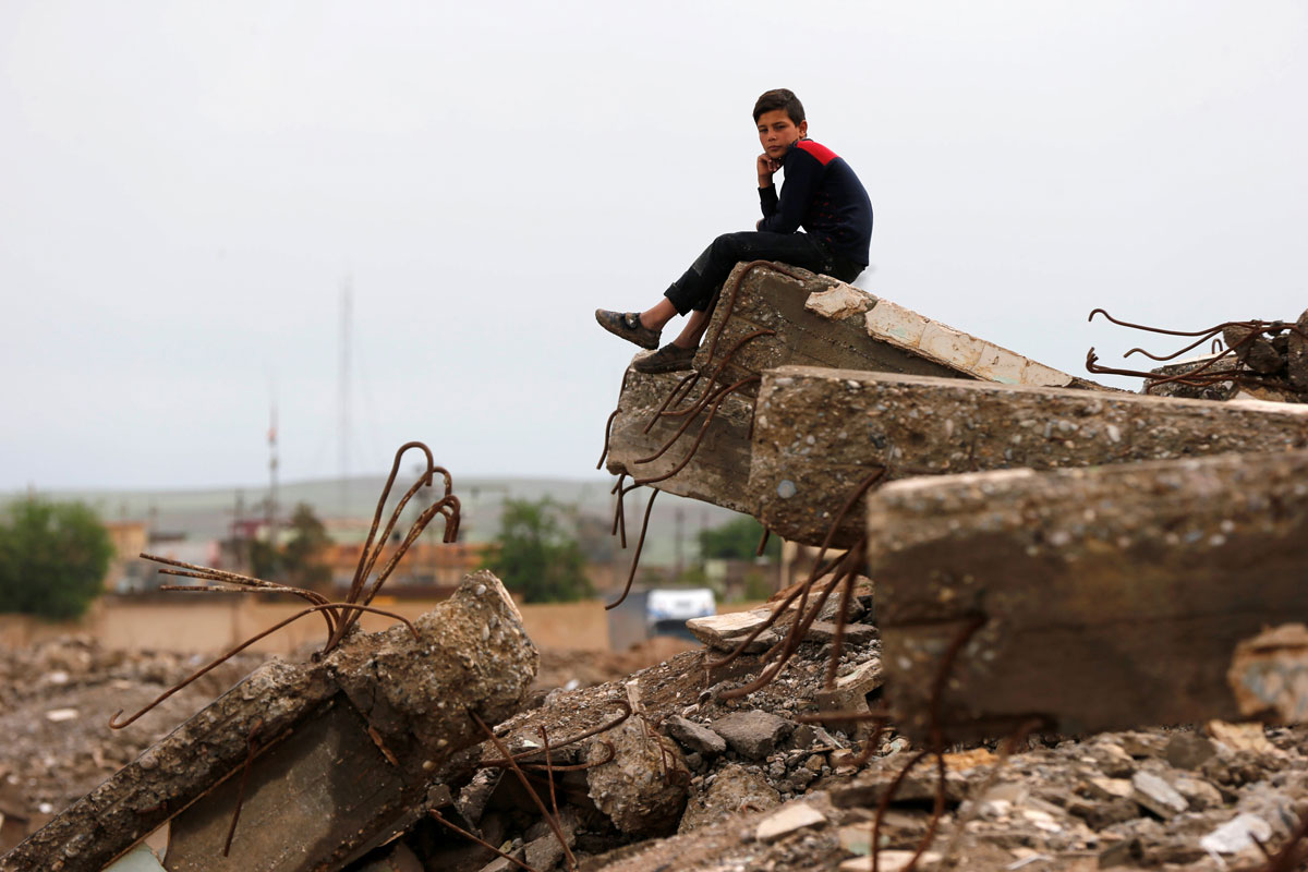 A displaced boy who had fled his home waits outside Hammam al-Alil camp south of Mosul, Iraq