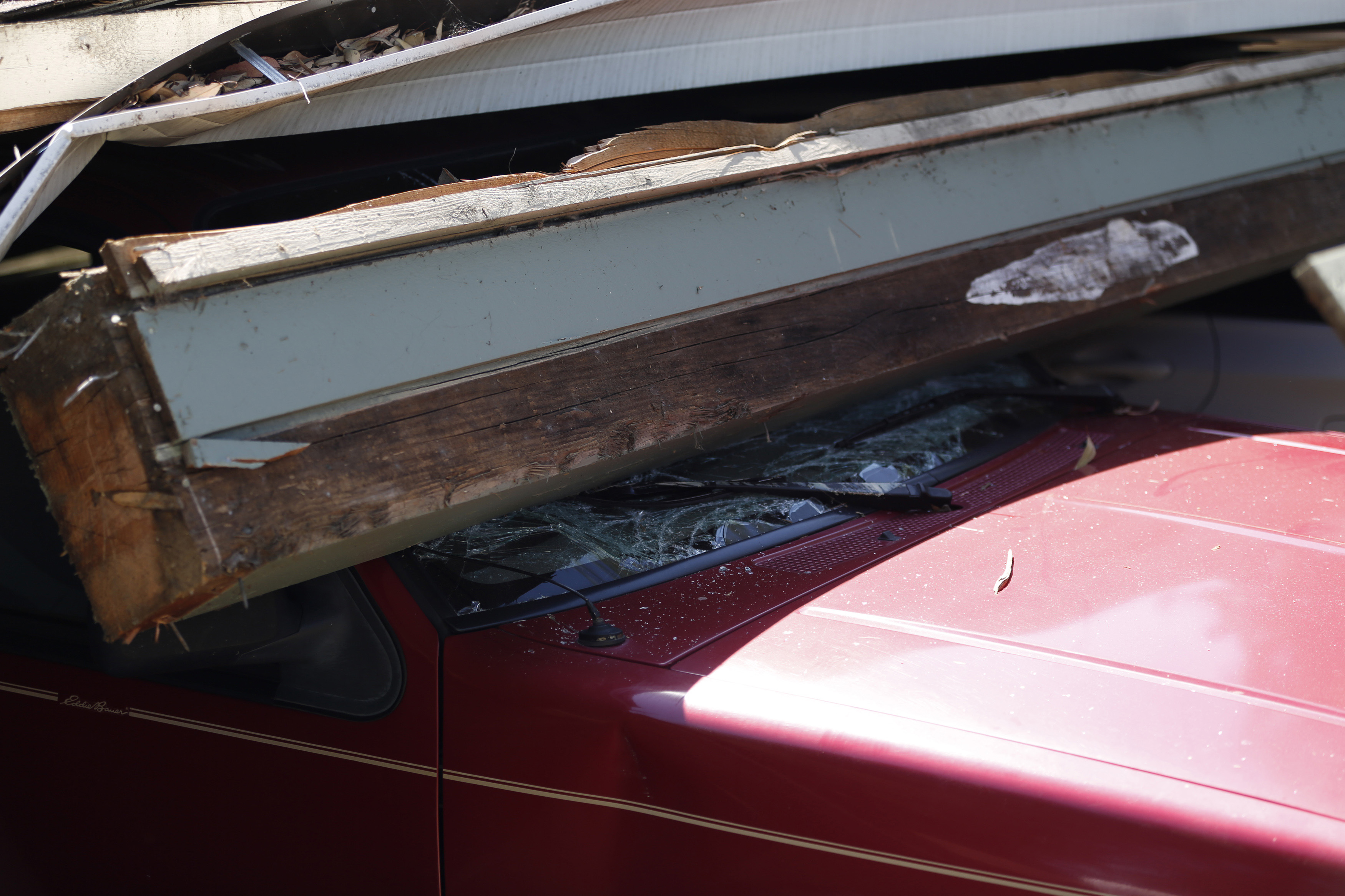 A damaged vehicle is seen under a collapsed parking structure in Napa