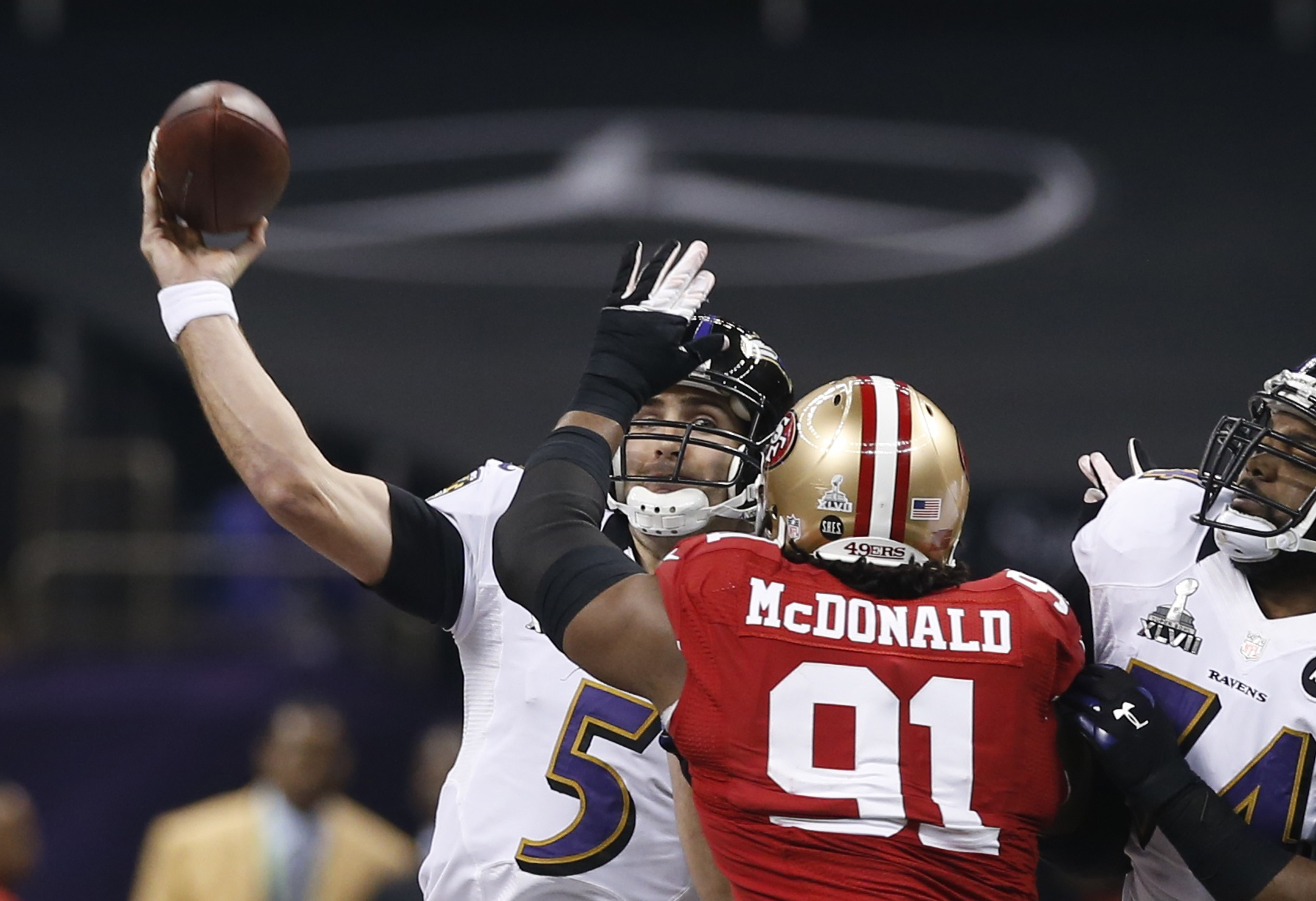 Baltimore Ravens' Flacco passes under pressure from San Francisco 49ers' McDonald during the first quarter in the NFL Super Bowl XLVII football game in New Orleans