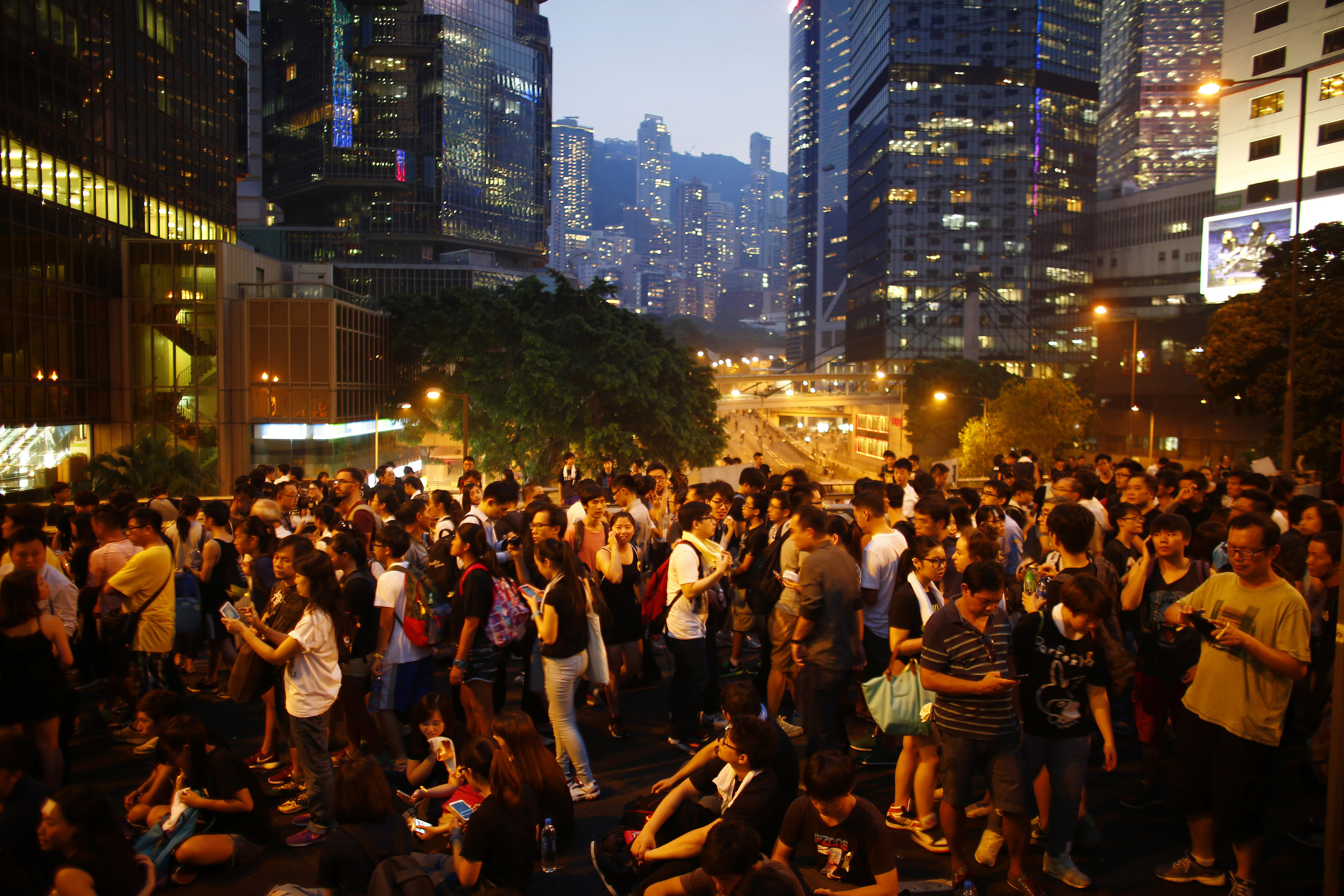 Protesters stand on a bridge as they block the main street to the financial Central district outside of the government headquarters building in Hong Kong