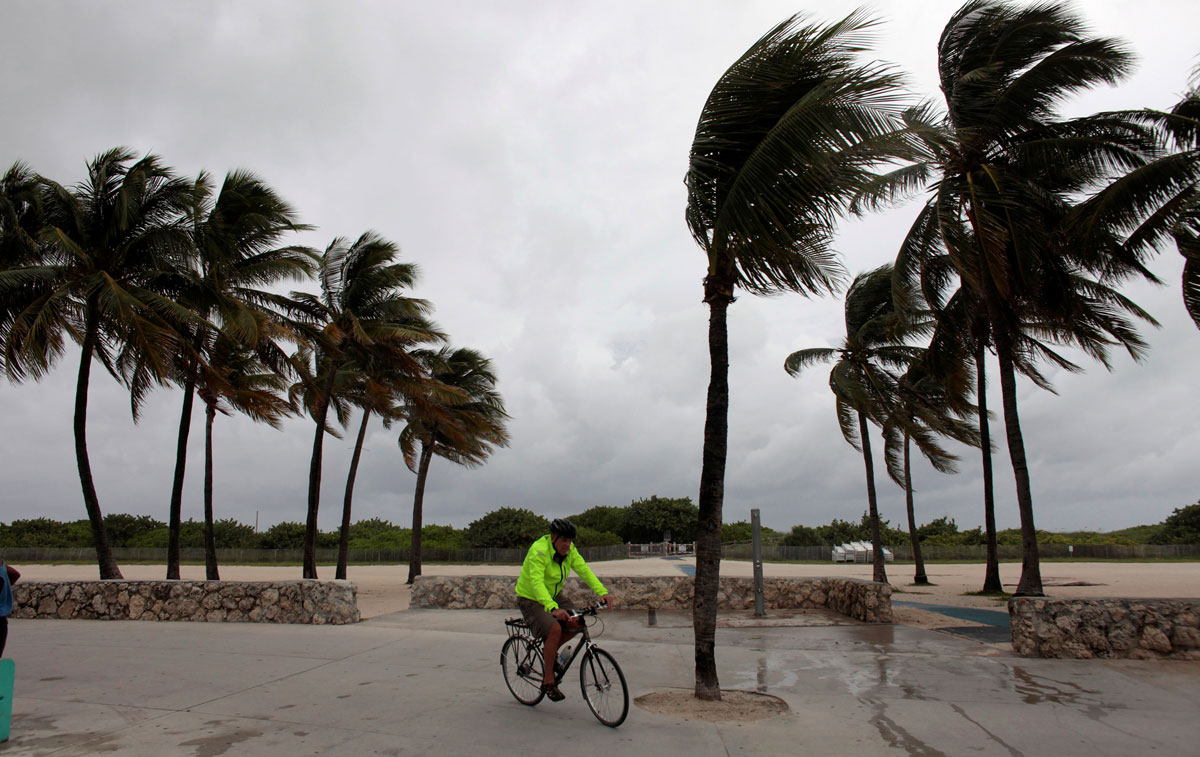 A man rides his bicycle along the beach prior to the arrival of Hurricane Matthew in Miami Beach