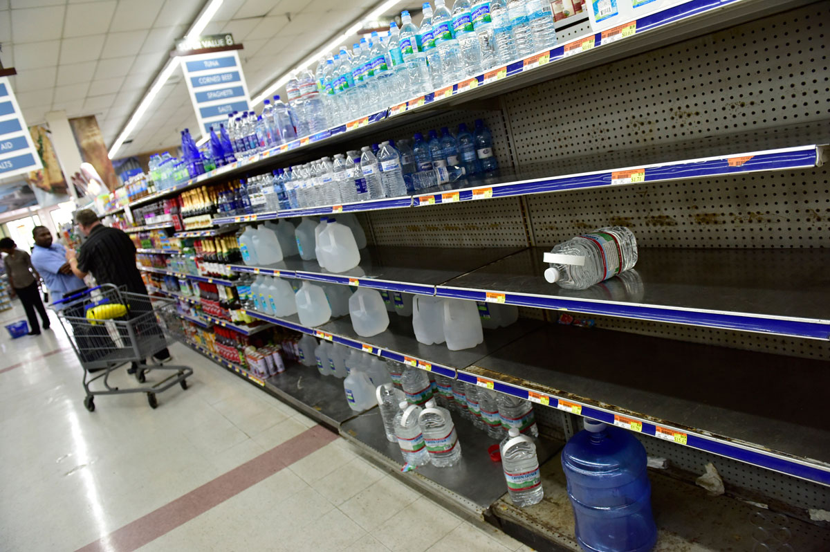 Bahamians buy bottled water as shelves begin to empty grocery store shelves around the city as Hurricane Matthew approaches Nassau