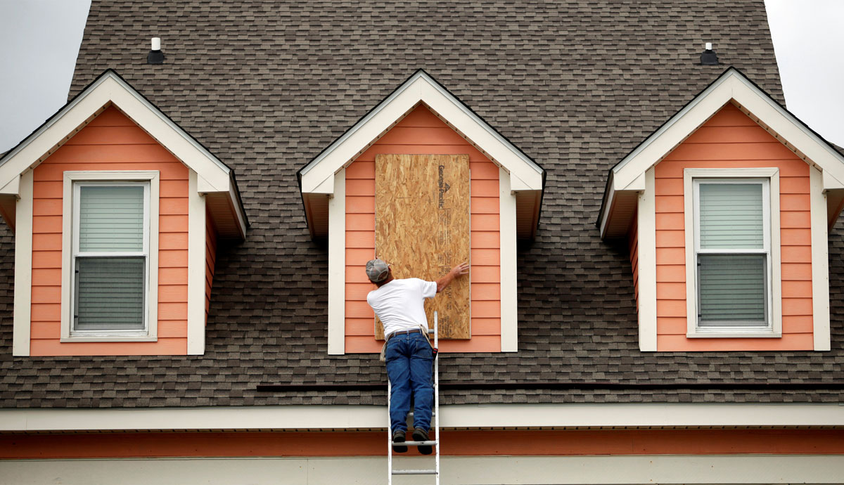 Brent Scurry of Lake City, South Carolina, works to install window shutters at an ocean front home in anticipation of Hurricane Matthew in Garden City Beach