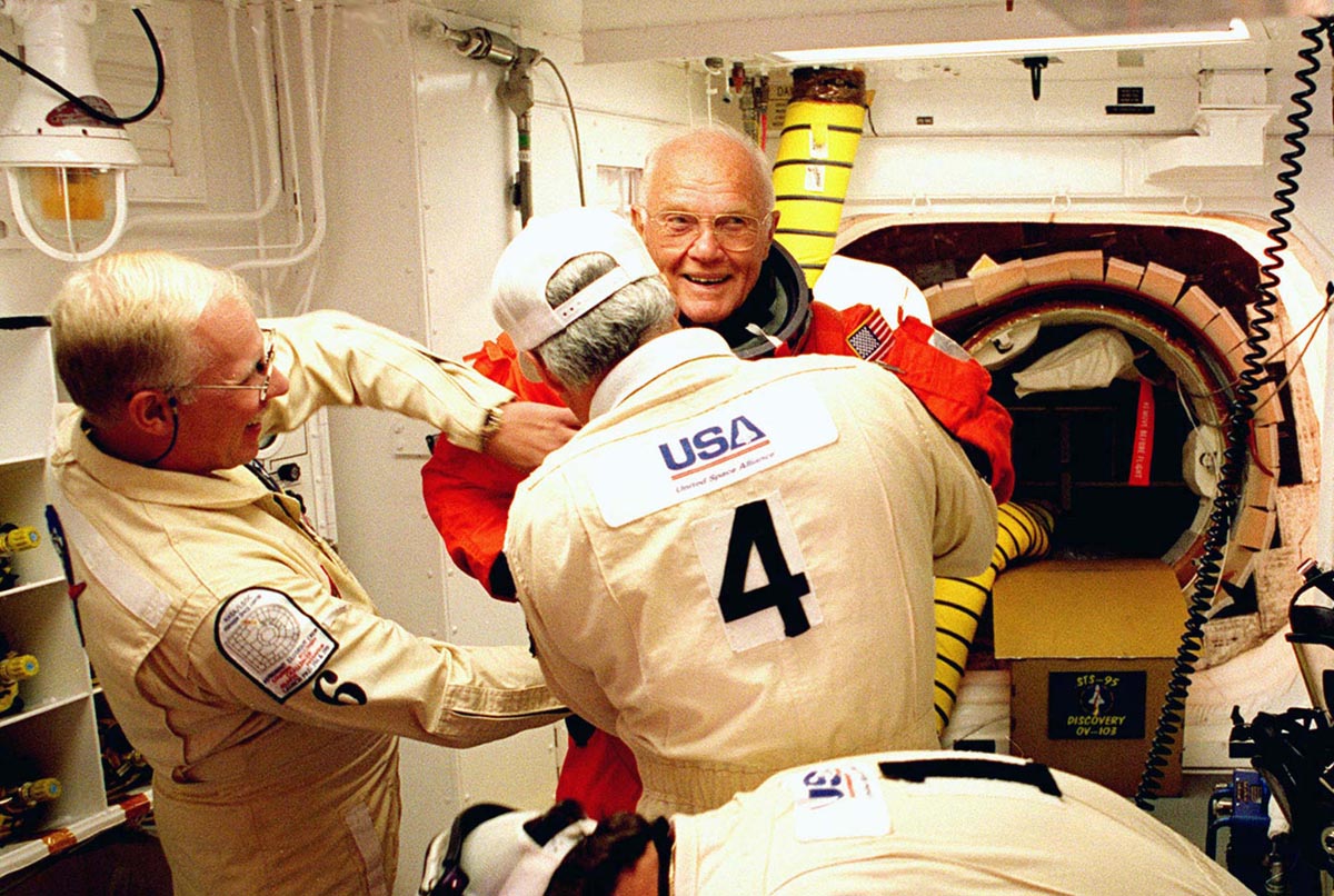 Astronaut John Glenn is assisted in the White Room as he entered the space shuttle Discovery prior t..