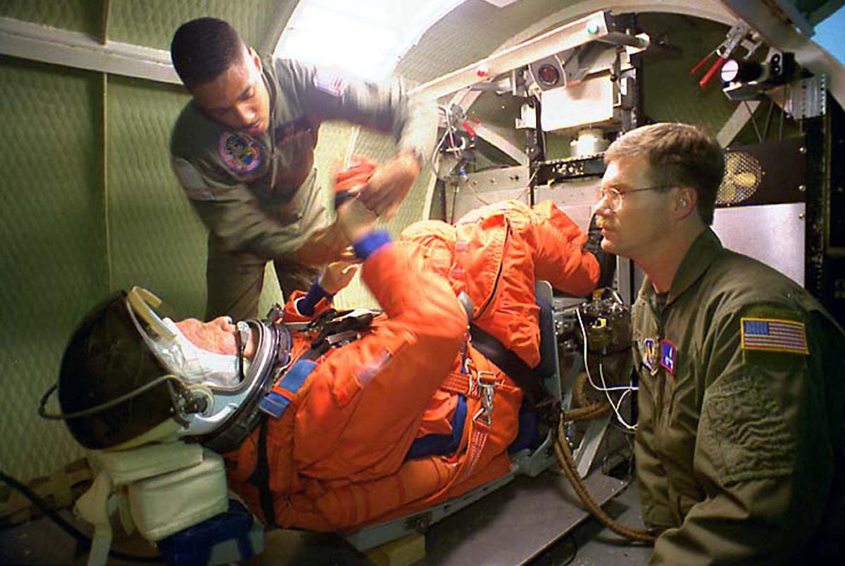 Sen. John Glenn, D-OH,  is strapped into a centrifuge by NASA's Carlous Gillis (L) and Technical Sgt..