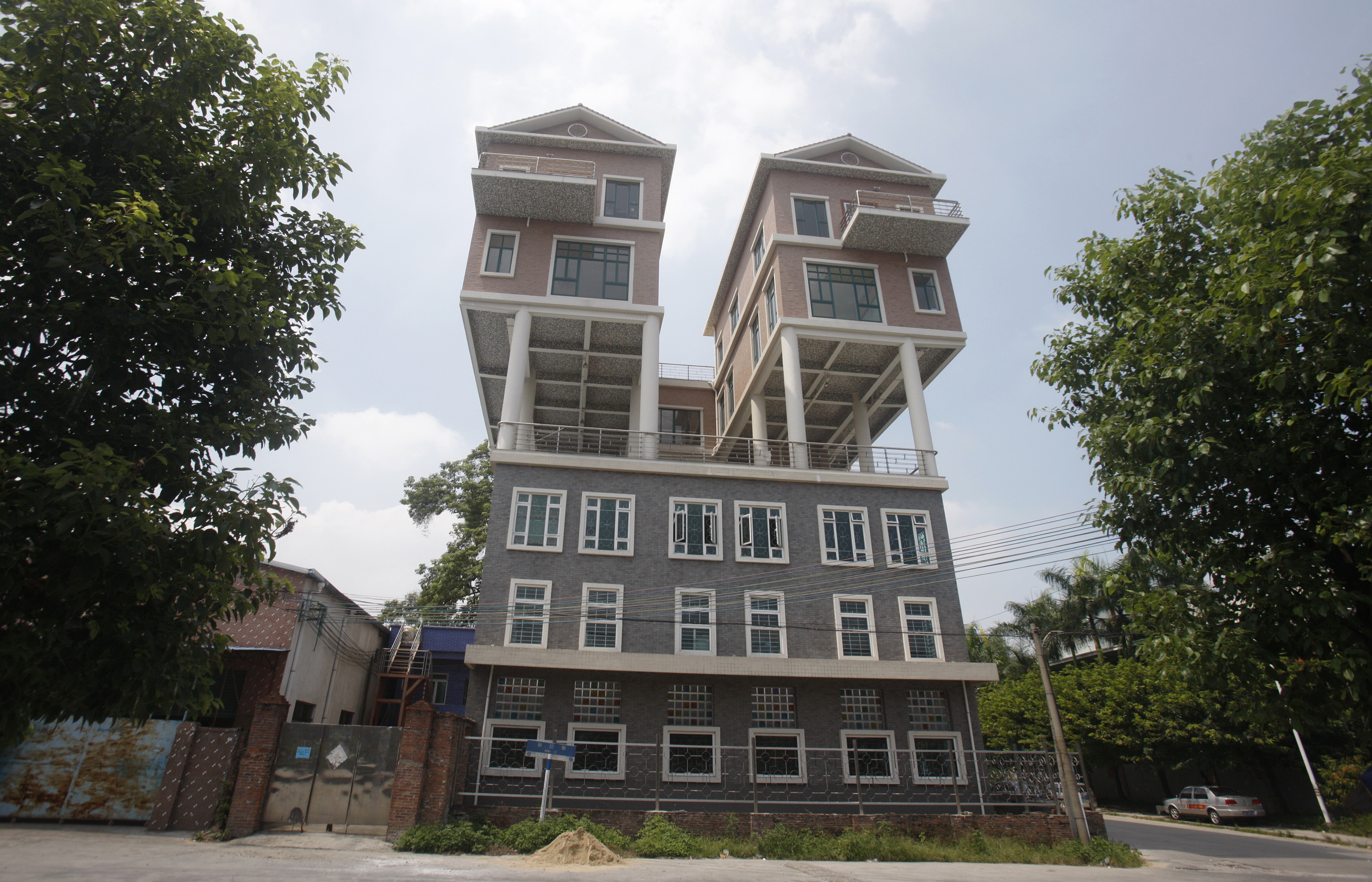 Houses are seen on the rooftop of a factory building in Dongguan