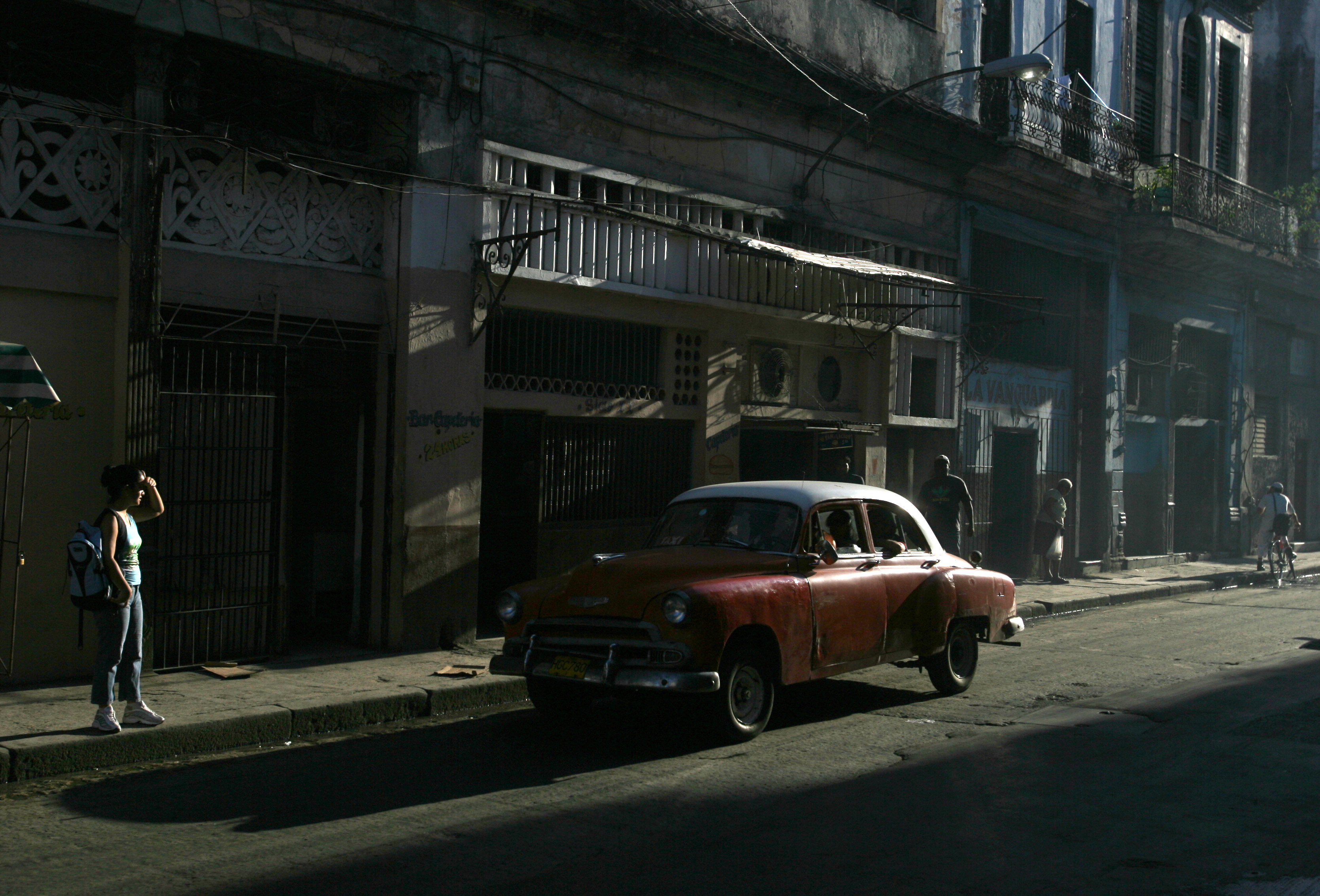 A vintage Chevrolet is driven down a street in Old Havana