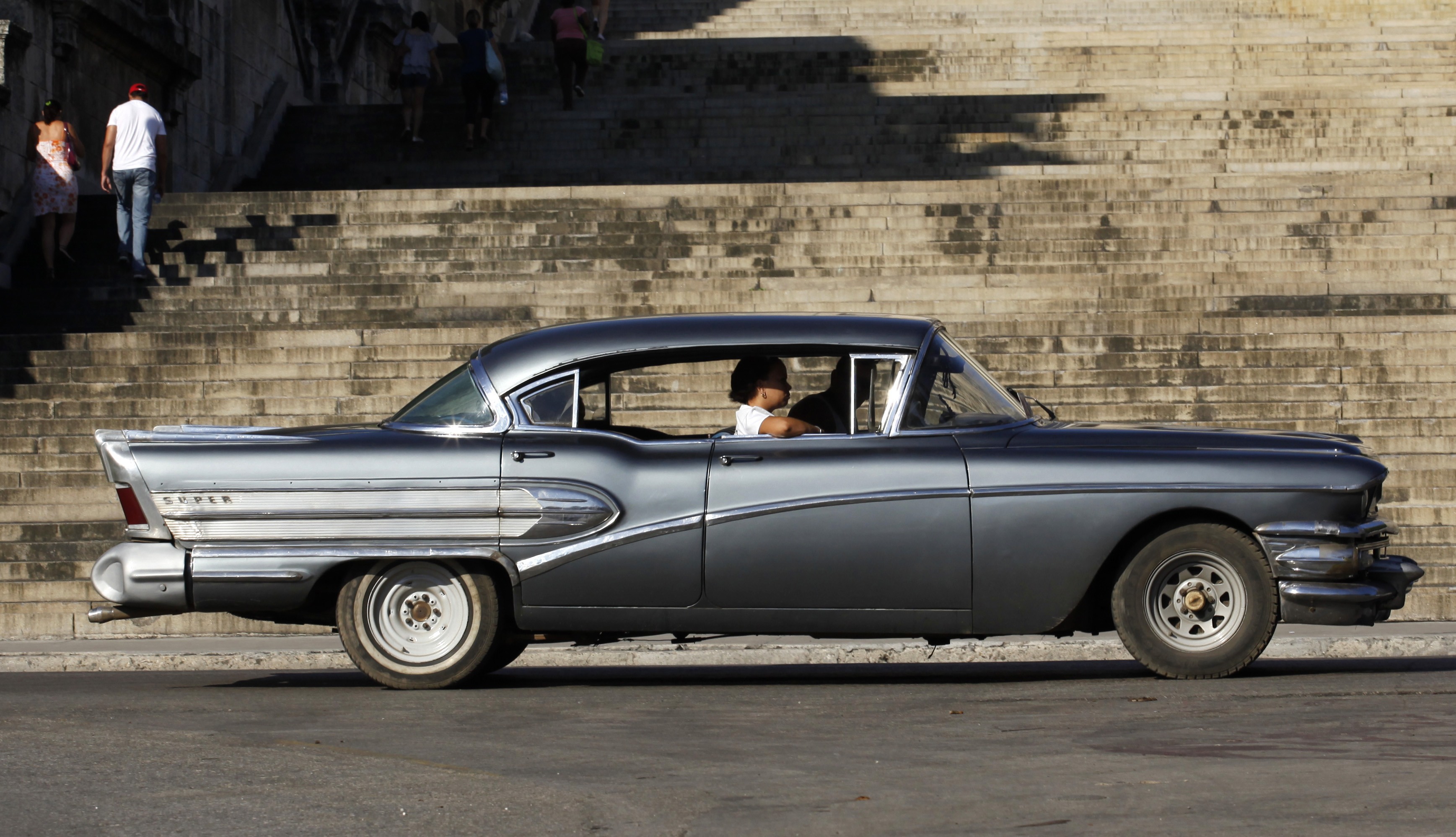 Vintage car drives by Havana University