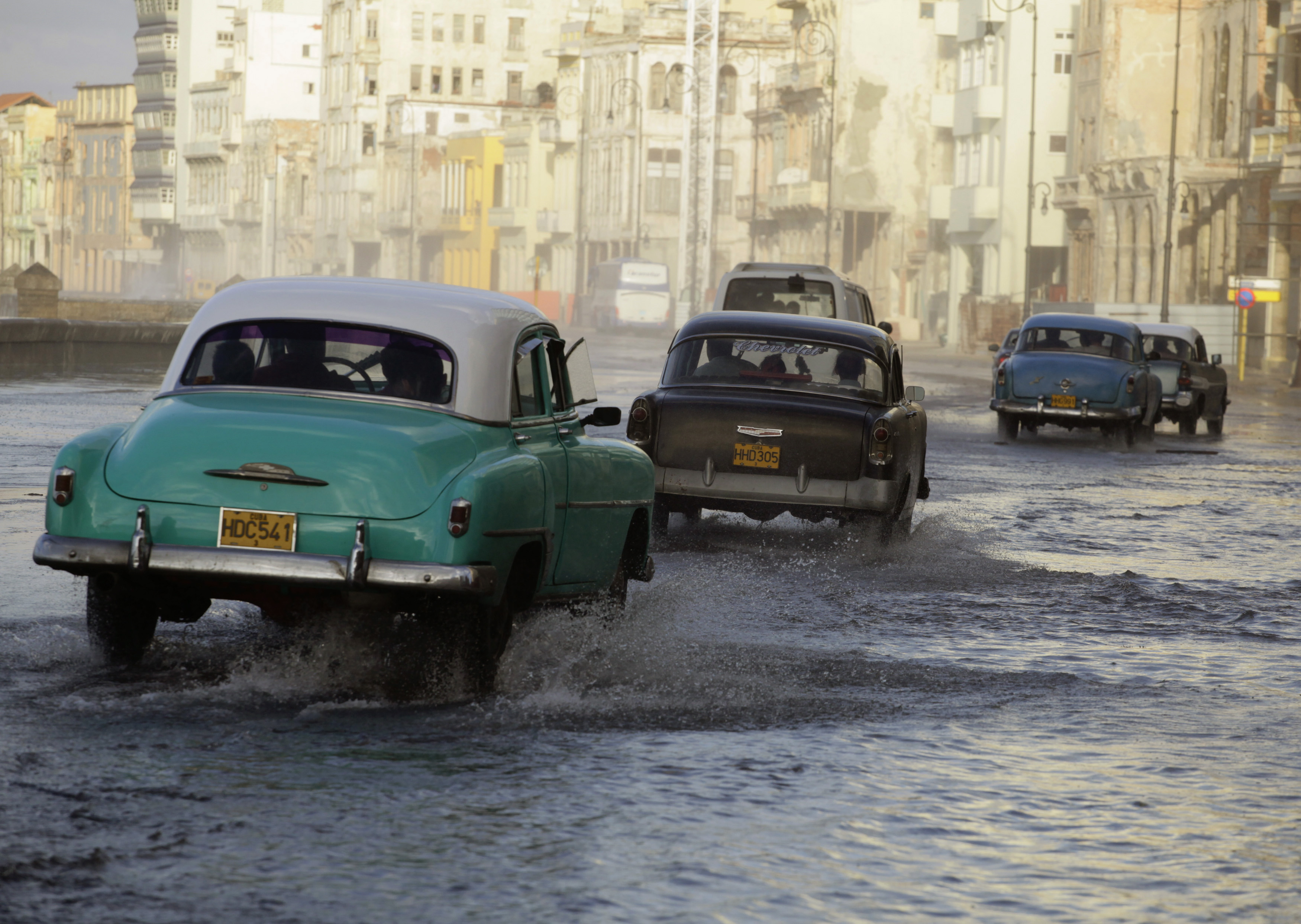 Cars are driven on Havana's flooded seafront boulevard 'El Malecon' as a cold front rolls over Havana