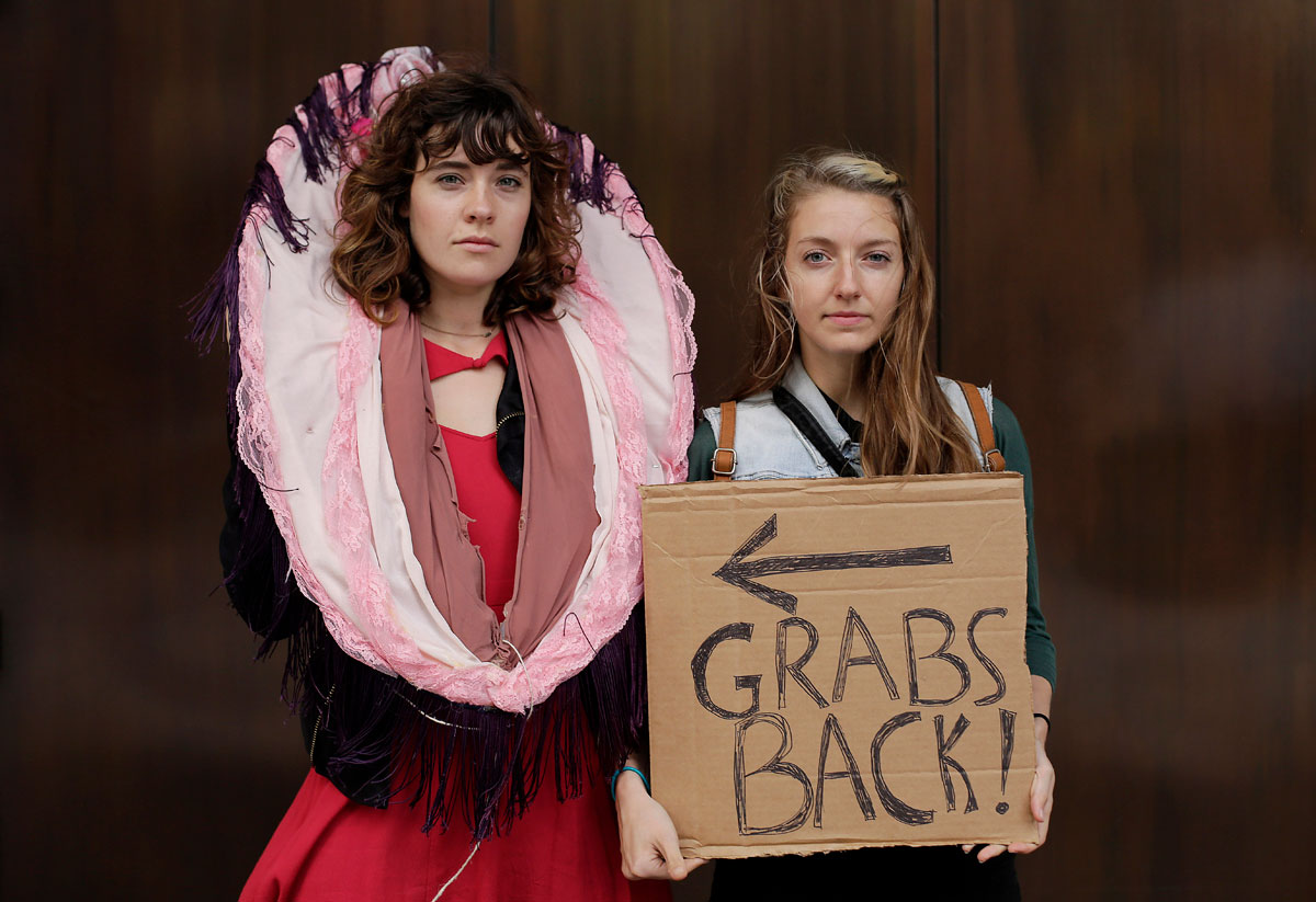 Eve Rydberg and Megan Lee pose for a portrait with their sign as they take part in a protest against Republican presidential candidate Donald Trump outside the Trump International Hotel and Tower in Chicago