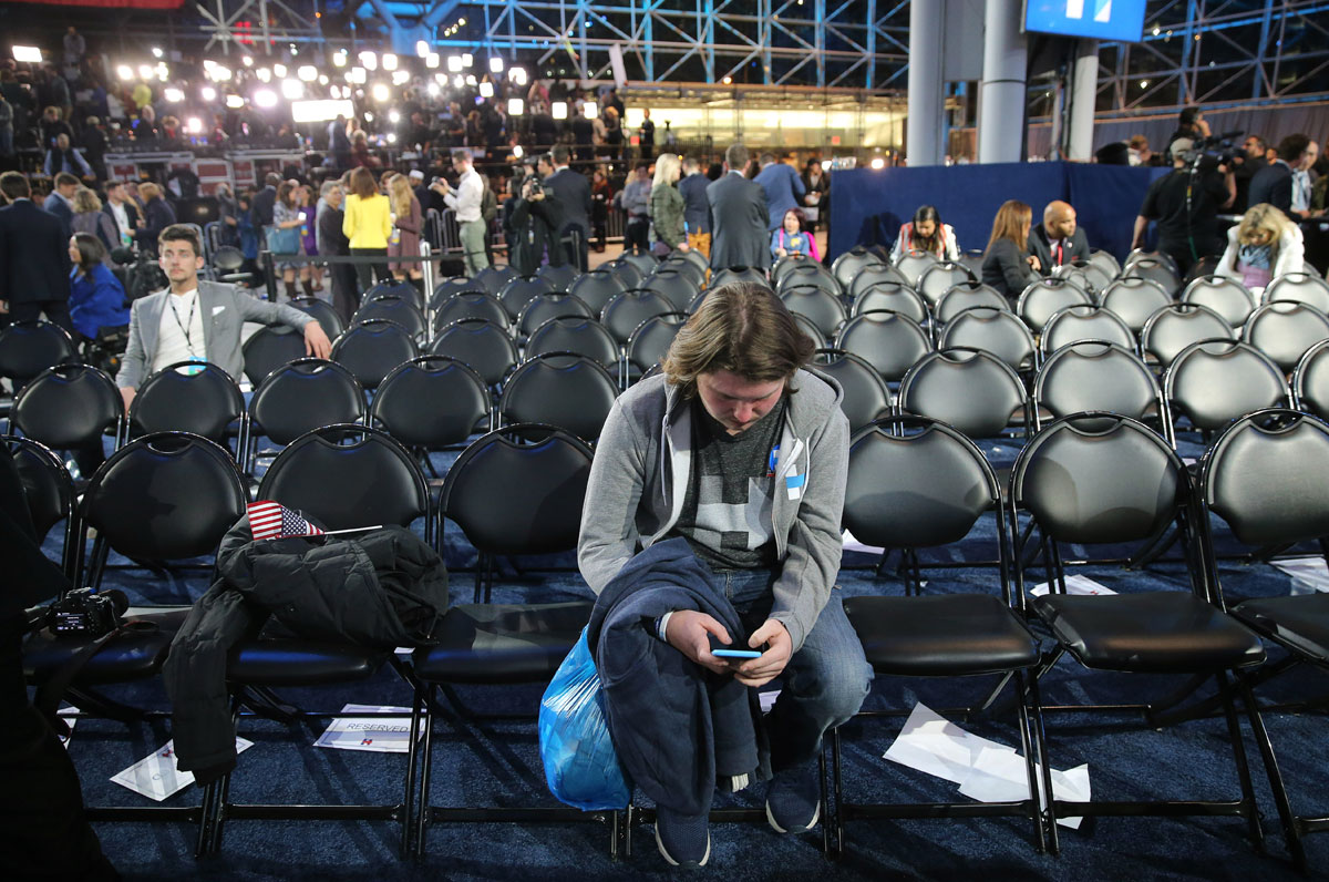 Supporter uses his smartphone as others leave Clinton rally in New York