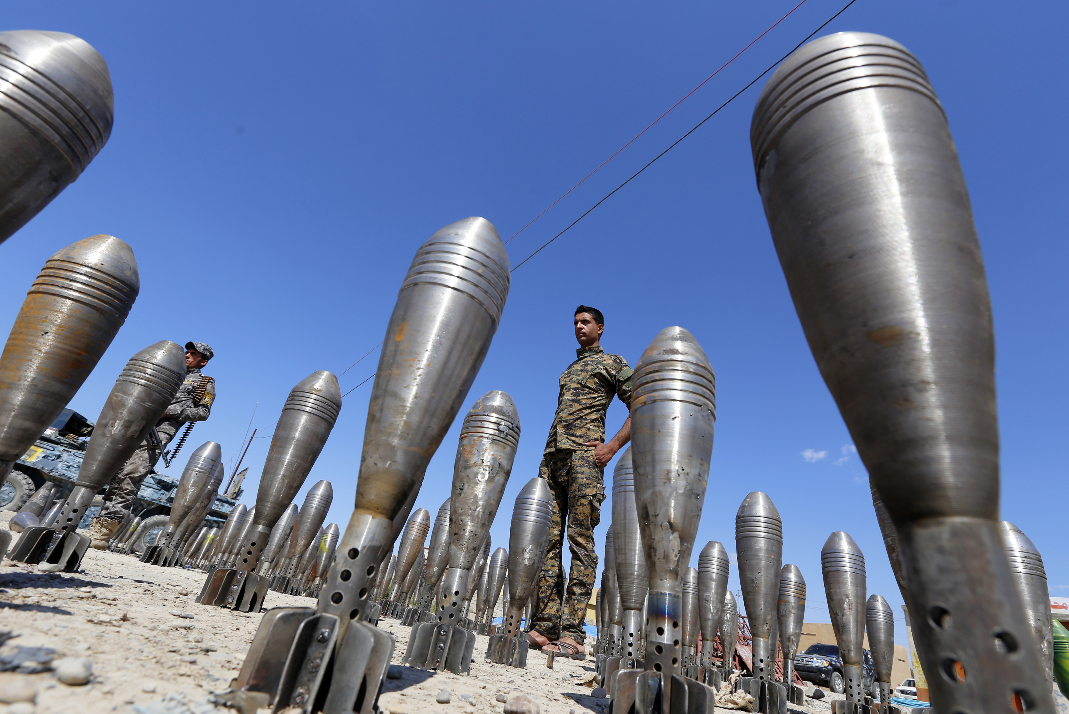 A member of the Iraqi security forces stands between Islamic State ammunition being displayed in al-Alam Salahuddin province