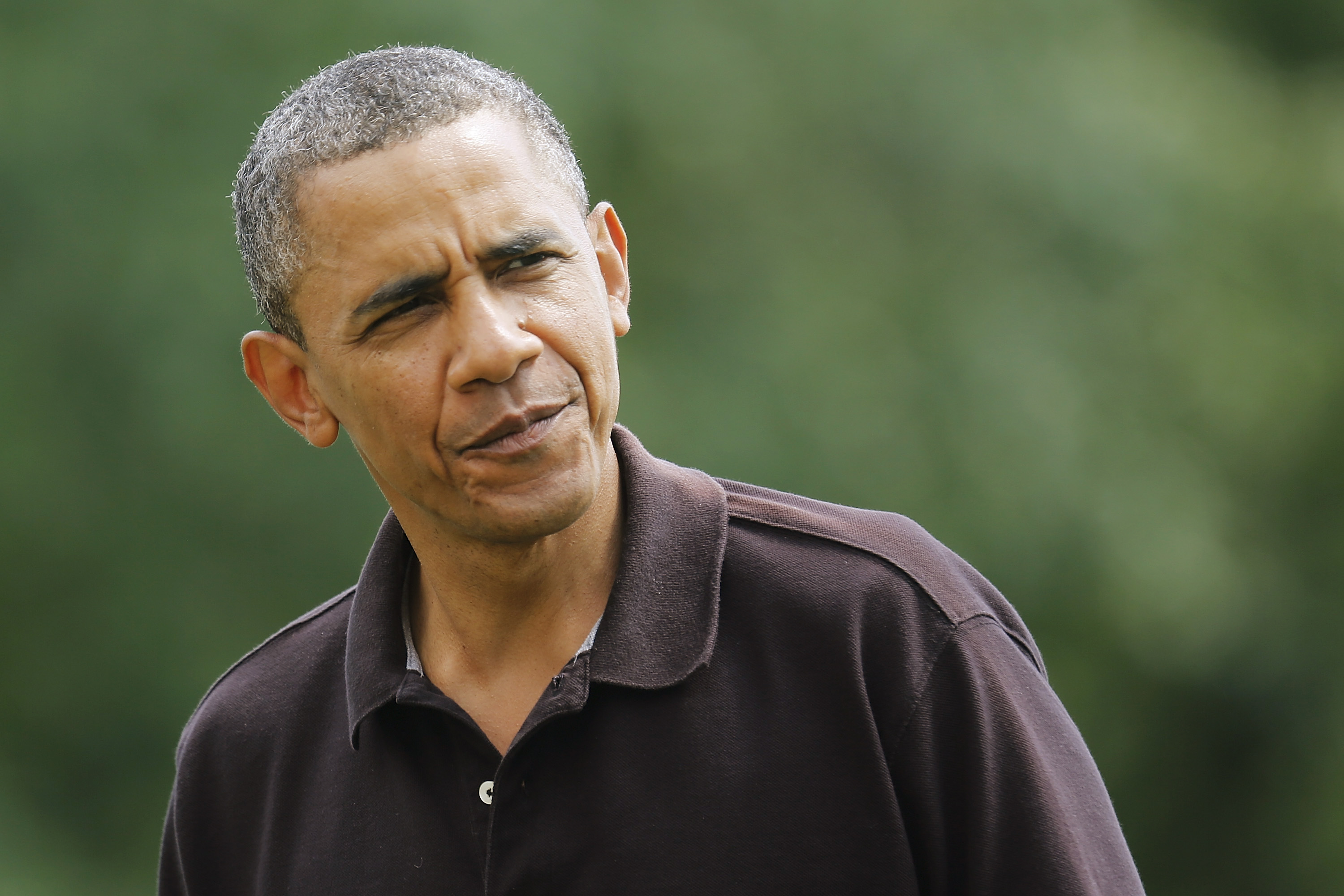 Obama looks at reporters as he returns from birthday visit at Camp David, to the White House in Washington