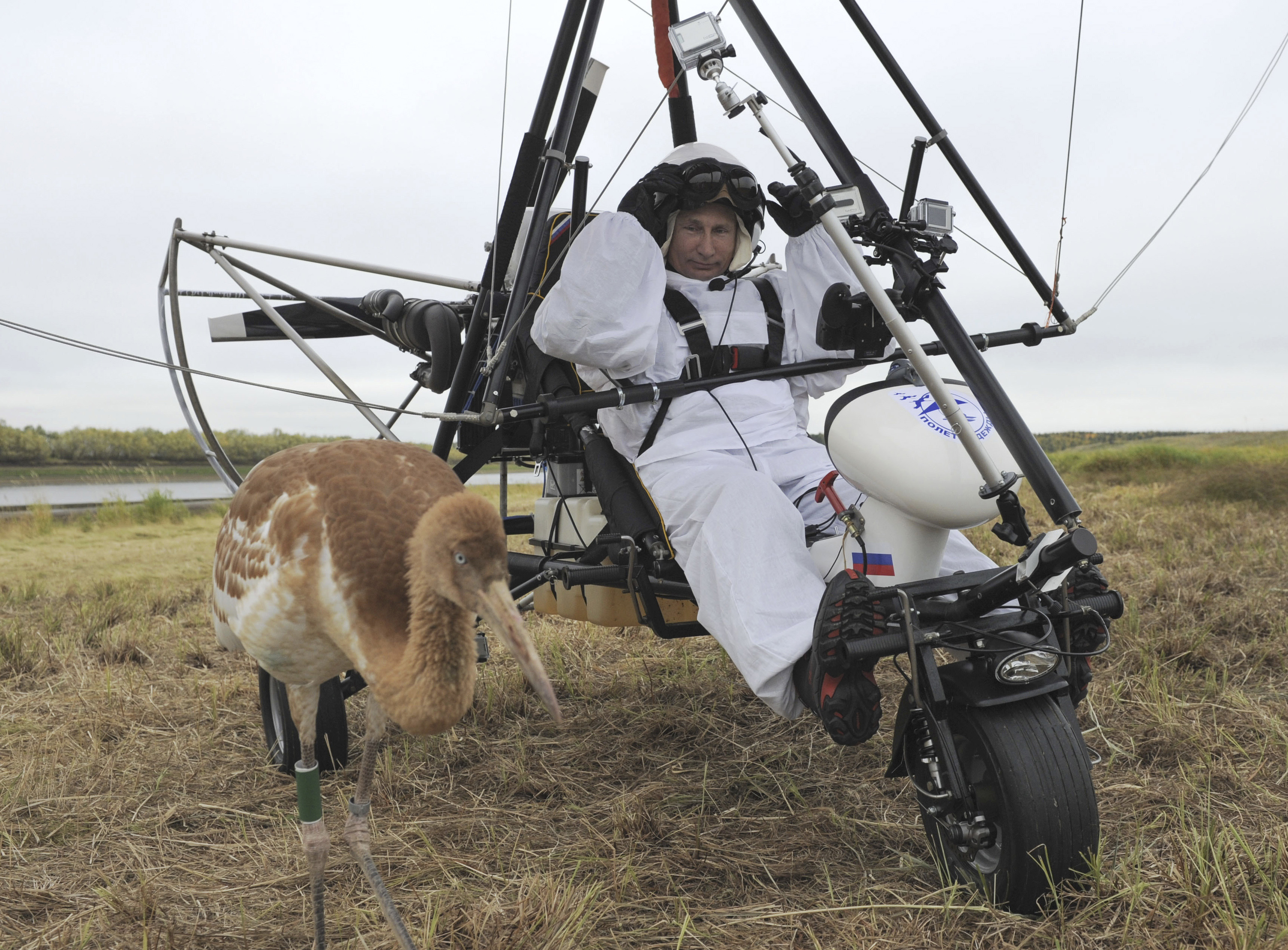 Russian President Vladimir Putin sits in a motorised deltaplane near a crane at Yamalo-Nenets district