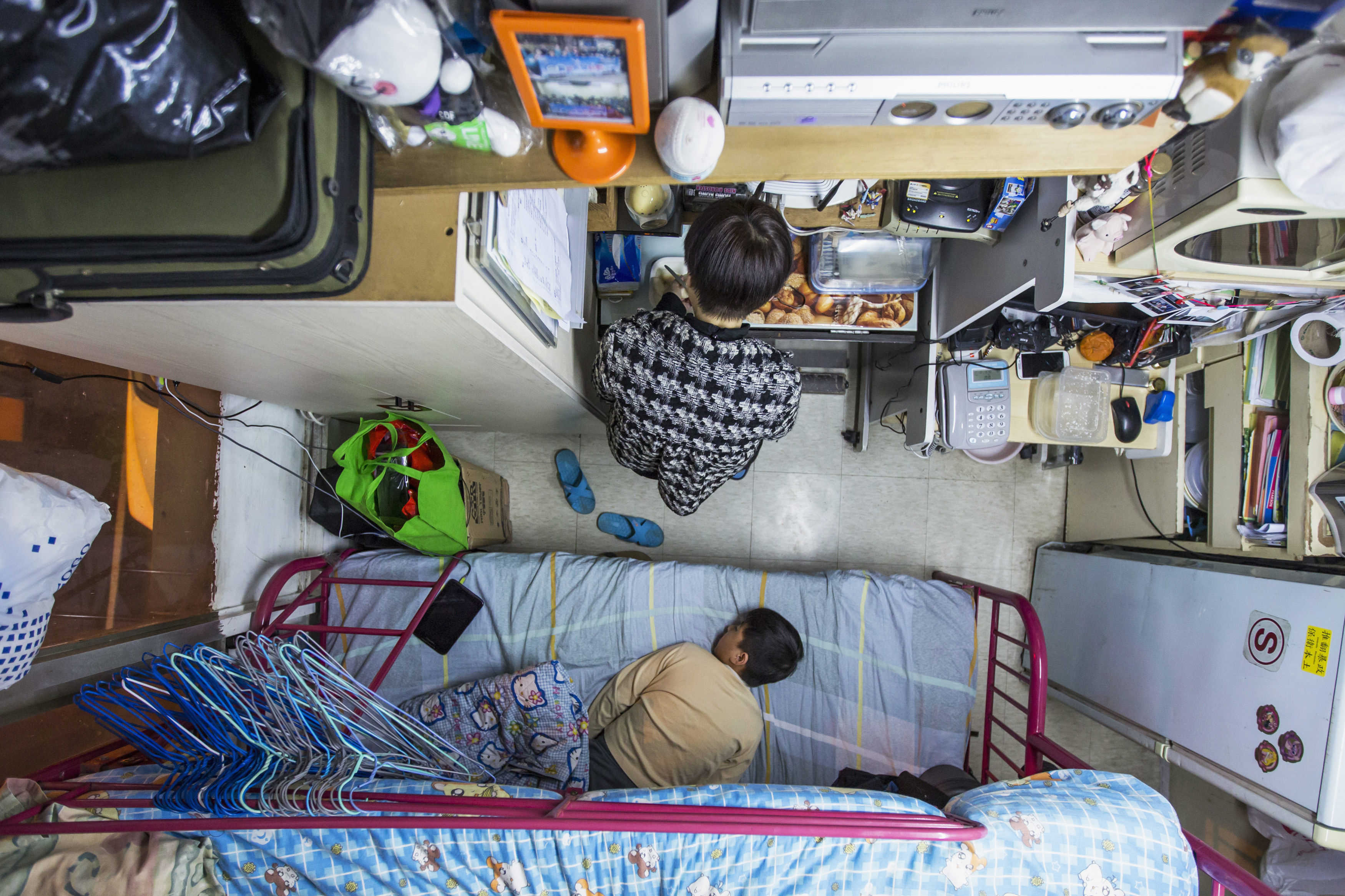 A woman and her son are seen in their 60-square-foot sub-divided flat in Hong Kong