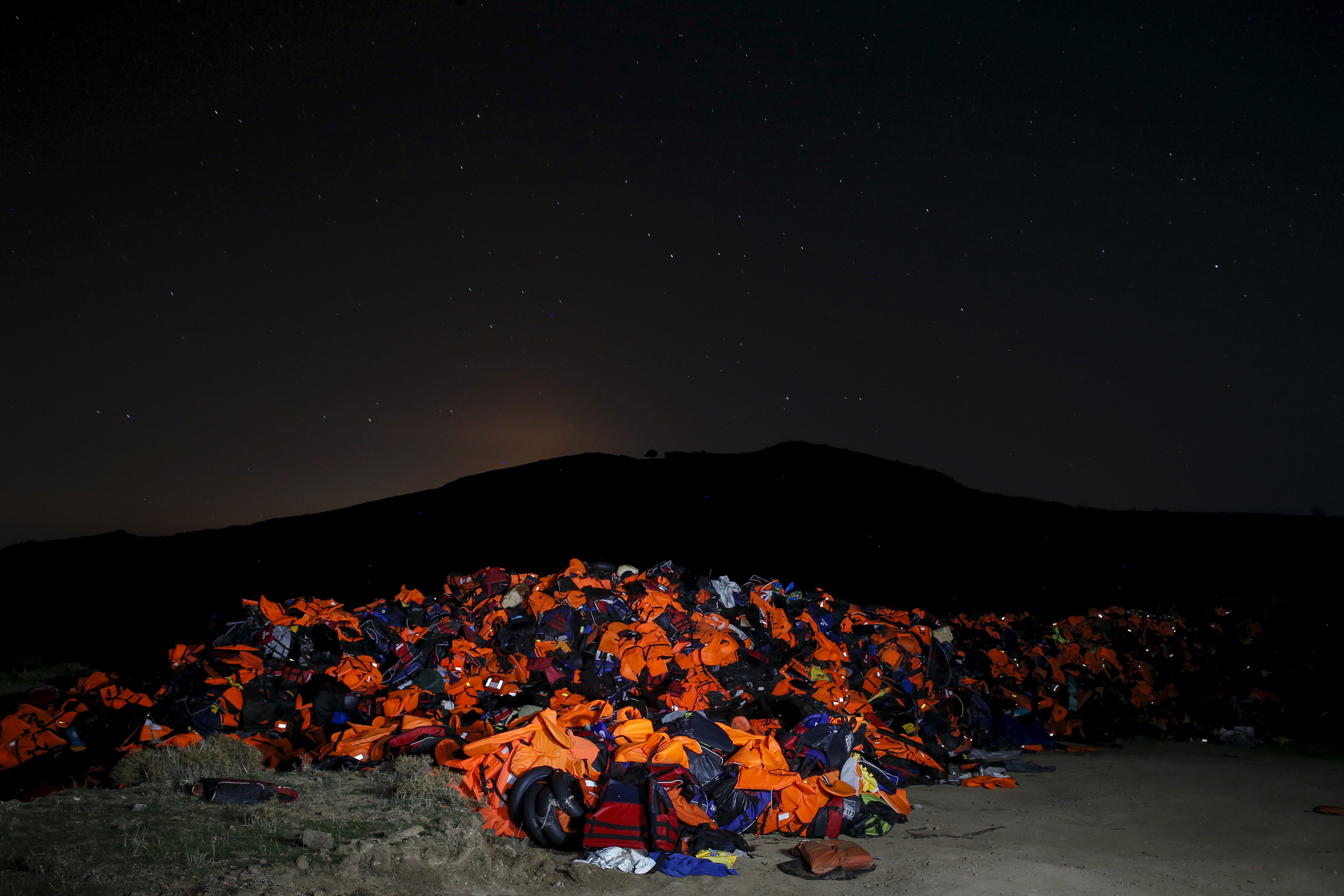 A long exposure photo shows thousands of lifejackets left by migrants and refugees, piled up at a garbage dump site on the Greek island of Lesbos