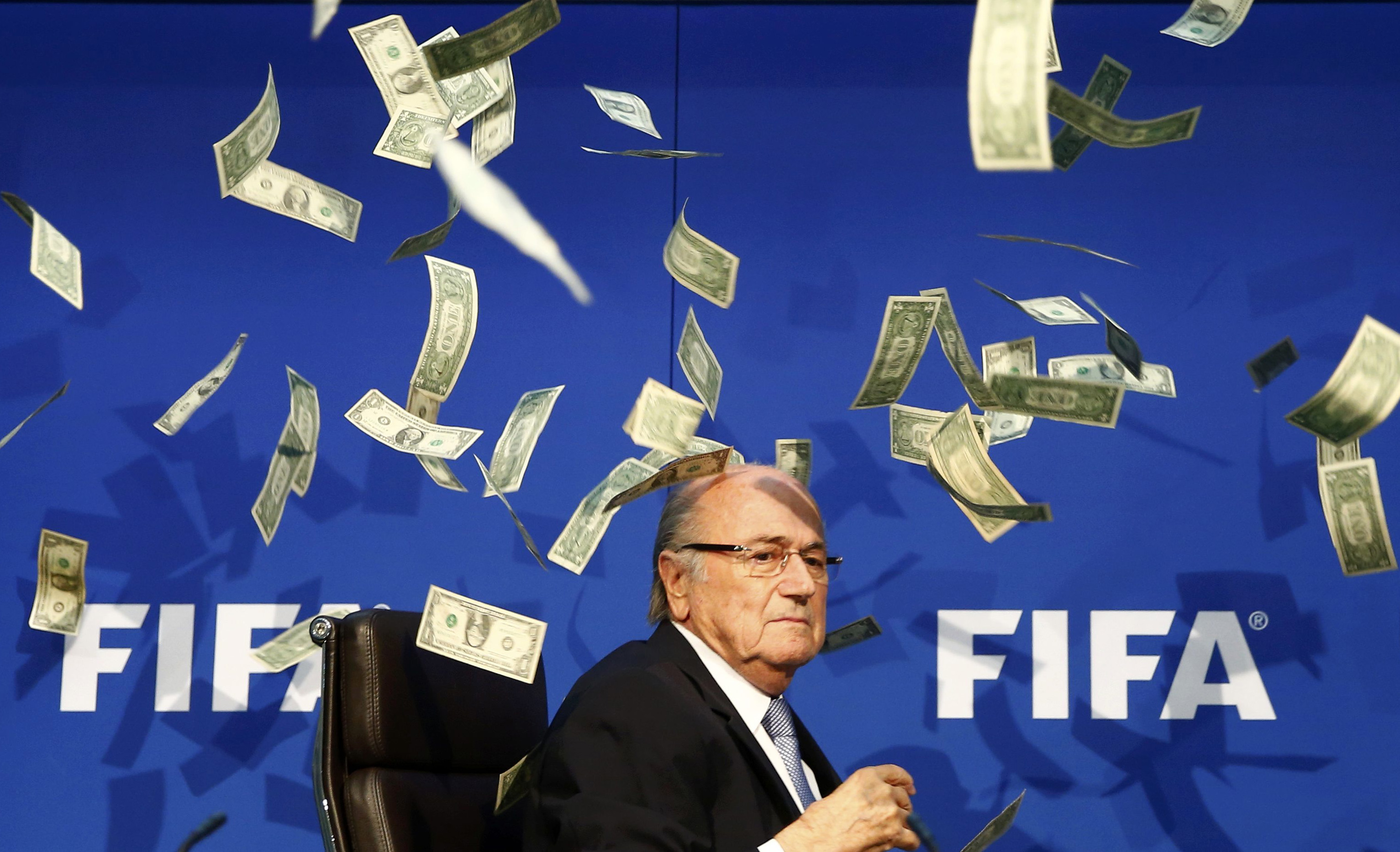 Banknotes are thrown at FIFA President Blatter as he arrives for a news conference after the Extraordinary FIFA Executive Committee Meeting at the FIFA headquarters in Zurich