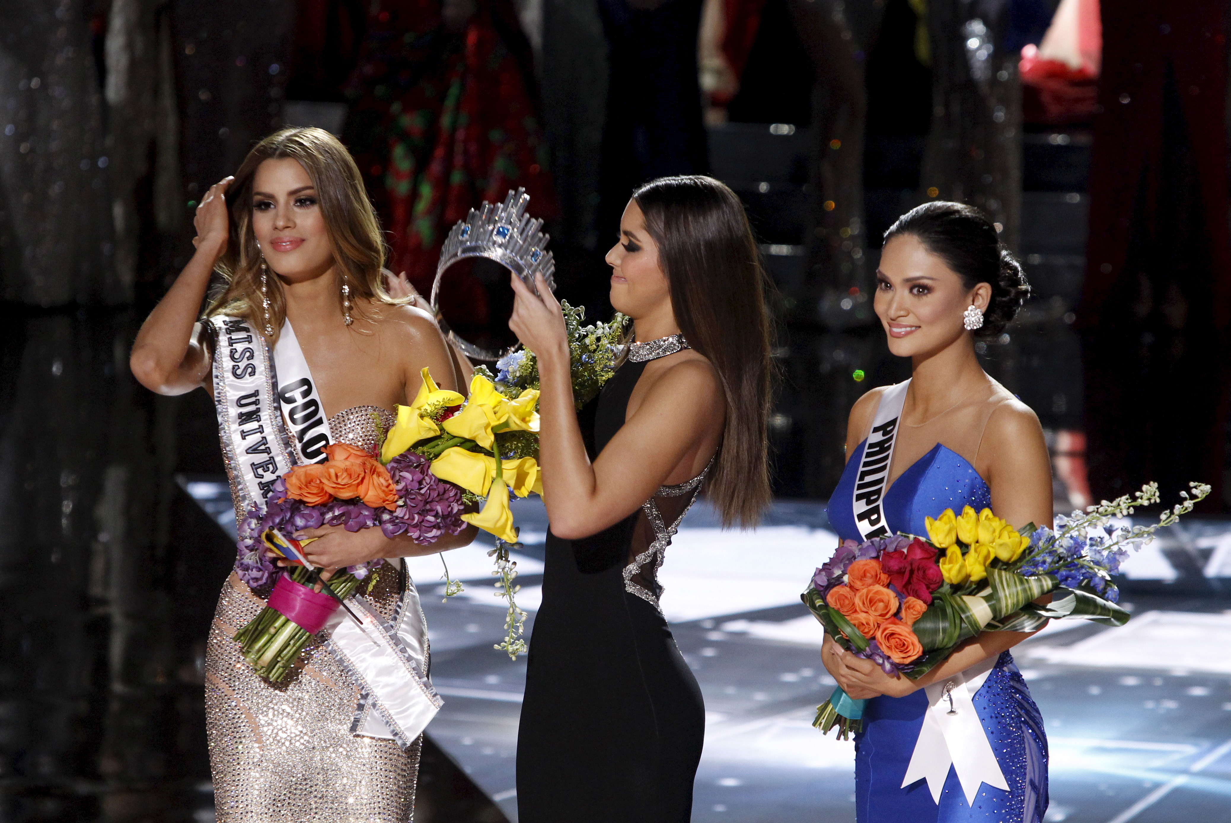 Miss Colombia Gutierrez stands by as Miss Universe 2014 Paulina Vega transfers the crown to winner Miss Philippines Wurtzbach during the 2015 Miss Universe Pageant in Las Vegas