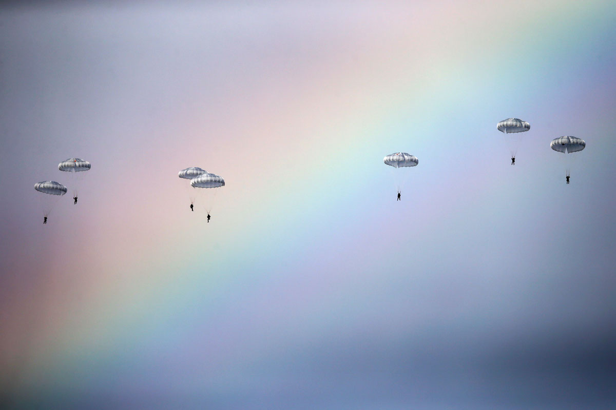 Russian paratroopers jump past rainbow from an IL-76 transport plane during a joint Serbian-Russian military training exercise "Slavic Brotherhood" in the town of Kovin