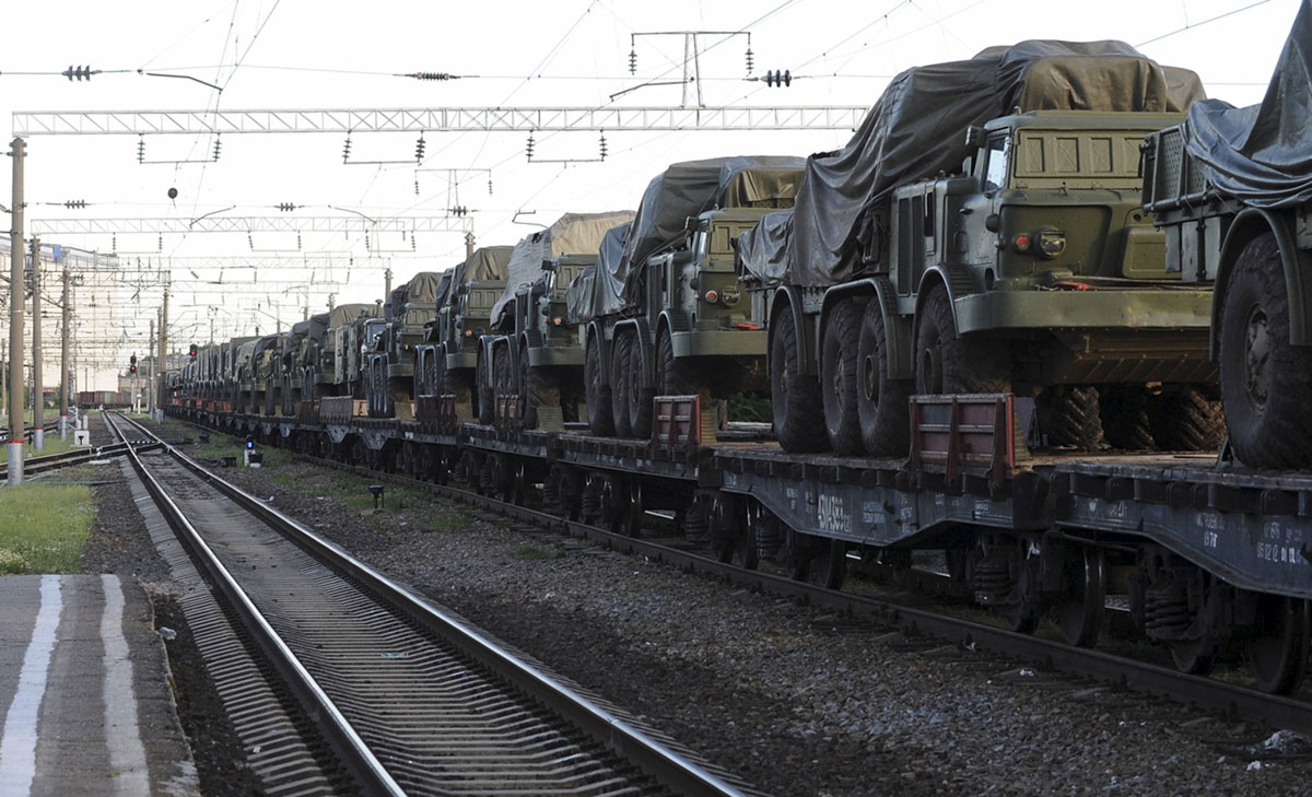 Multiple launch rocket systems and military trucks are seen on freight train platforms in the Russian southern town of Matveev Kurgan