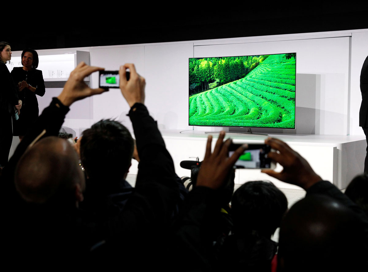 Journalists take photos of a new QLED television during a Samsung Electronics news conference at the 2017 CES in Las Vegas