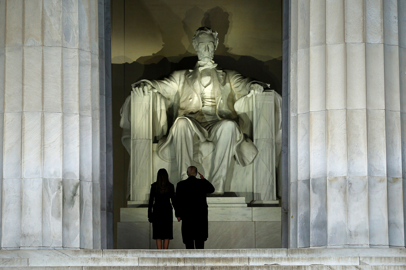 Trump salutes the statue of Abraham Lincoln as he and his wife take part in a Make America Great Again welcome concert in Washington