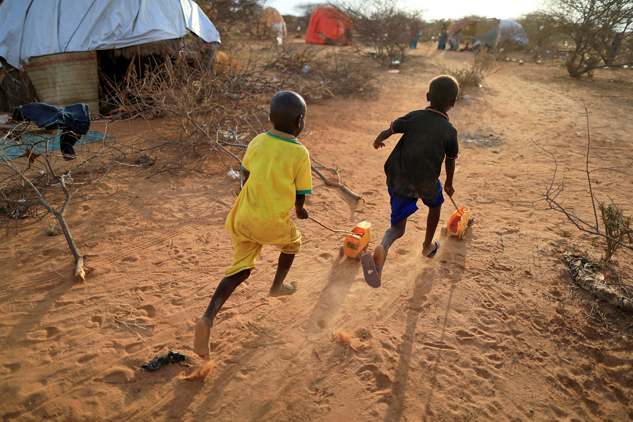 Internally displaced boys from a drought hit area play with handmade toys at a makeshift settlement in Dollow, Somalia