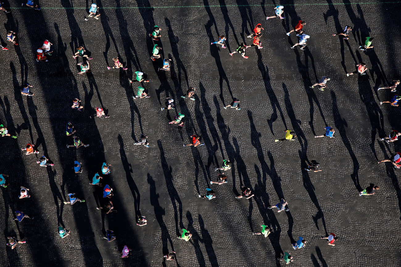 Competitors run down the Champs Elysees below the Arc de Triomphe at the start of the 41st Paris Marathon in Paris
