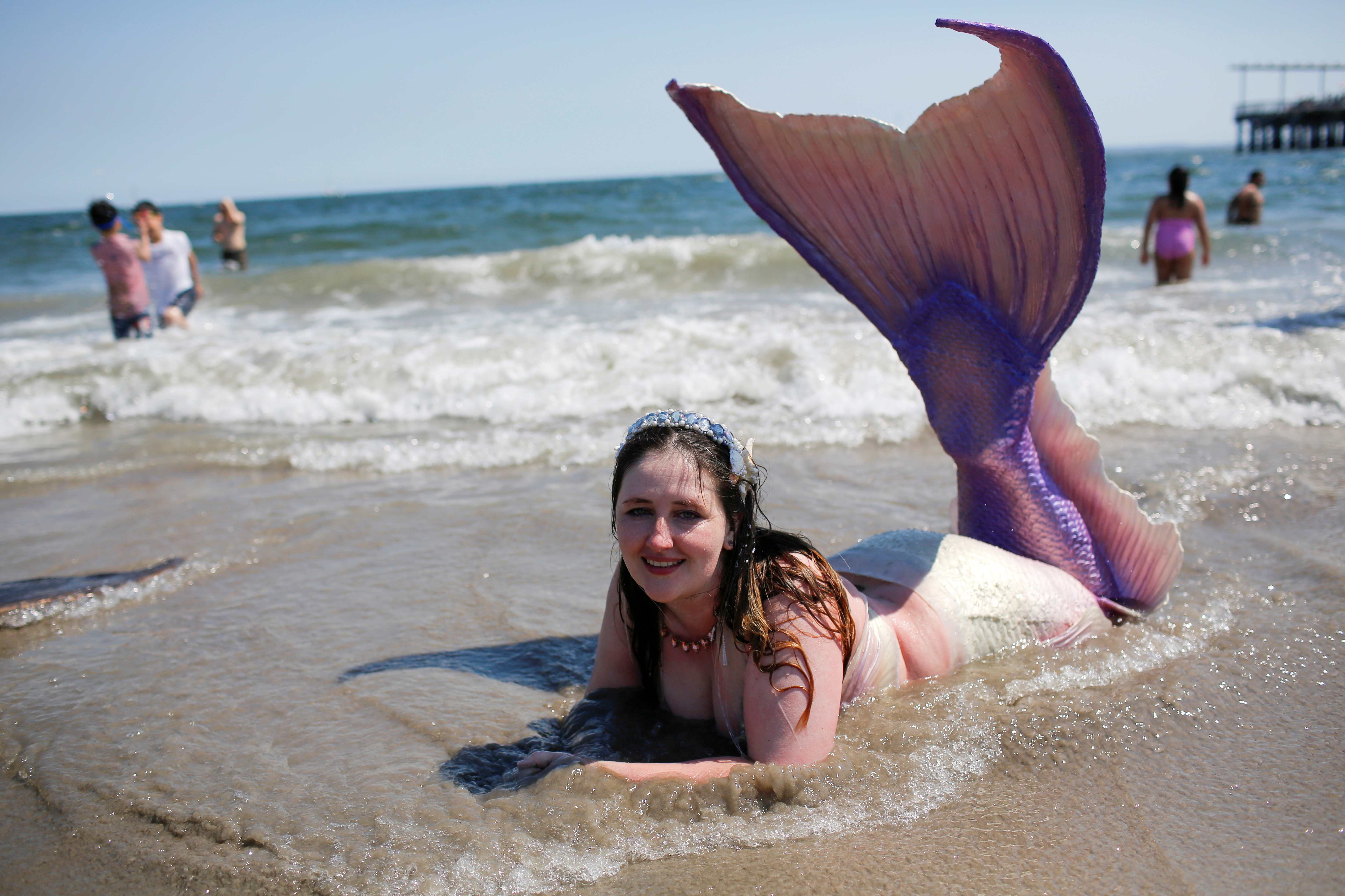 A participant dressed as a mermaid goes to swim in the beach after taking part in the Annual Mermaid Parade in Brooklyn