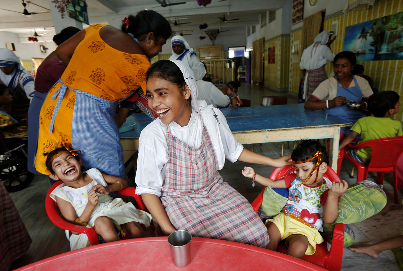 A nun belonging to the global Missionaries of Charity reacts as she interacts with children at the Nirmala Shishu Bhavan in Kolkata