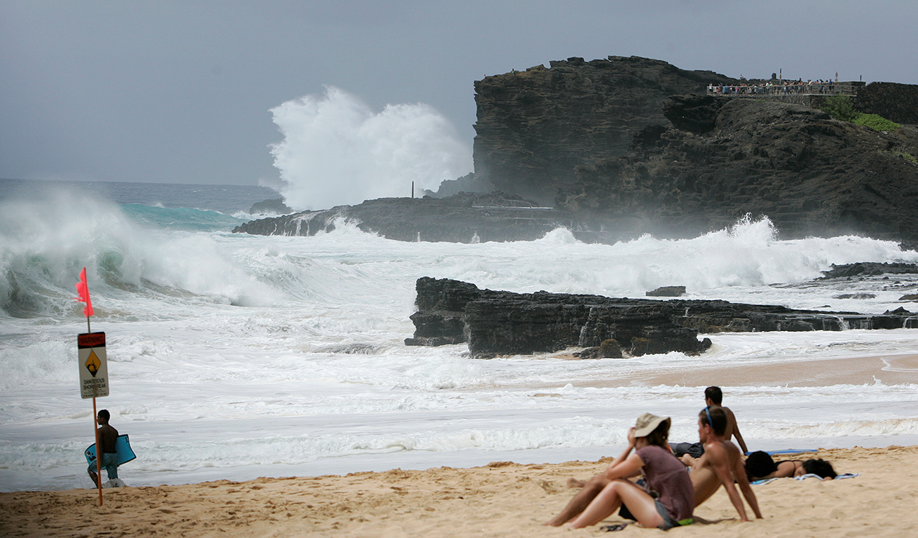 Large waves generated by Hurricane Lester crash against the sea cliffs at Sandys Beach park in Honolulu, Hawaii.