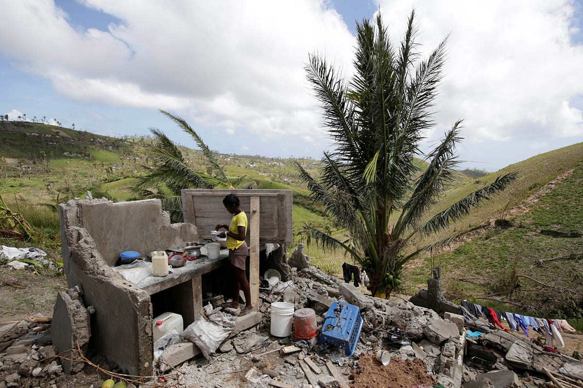 A woman cooks in the kitchen of her house destroyed by Hurricane Matthew on the outskirts of Port Salut, Haiti