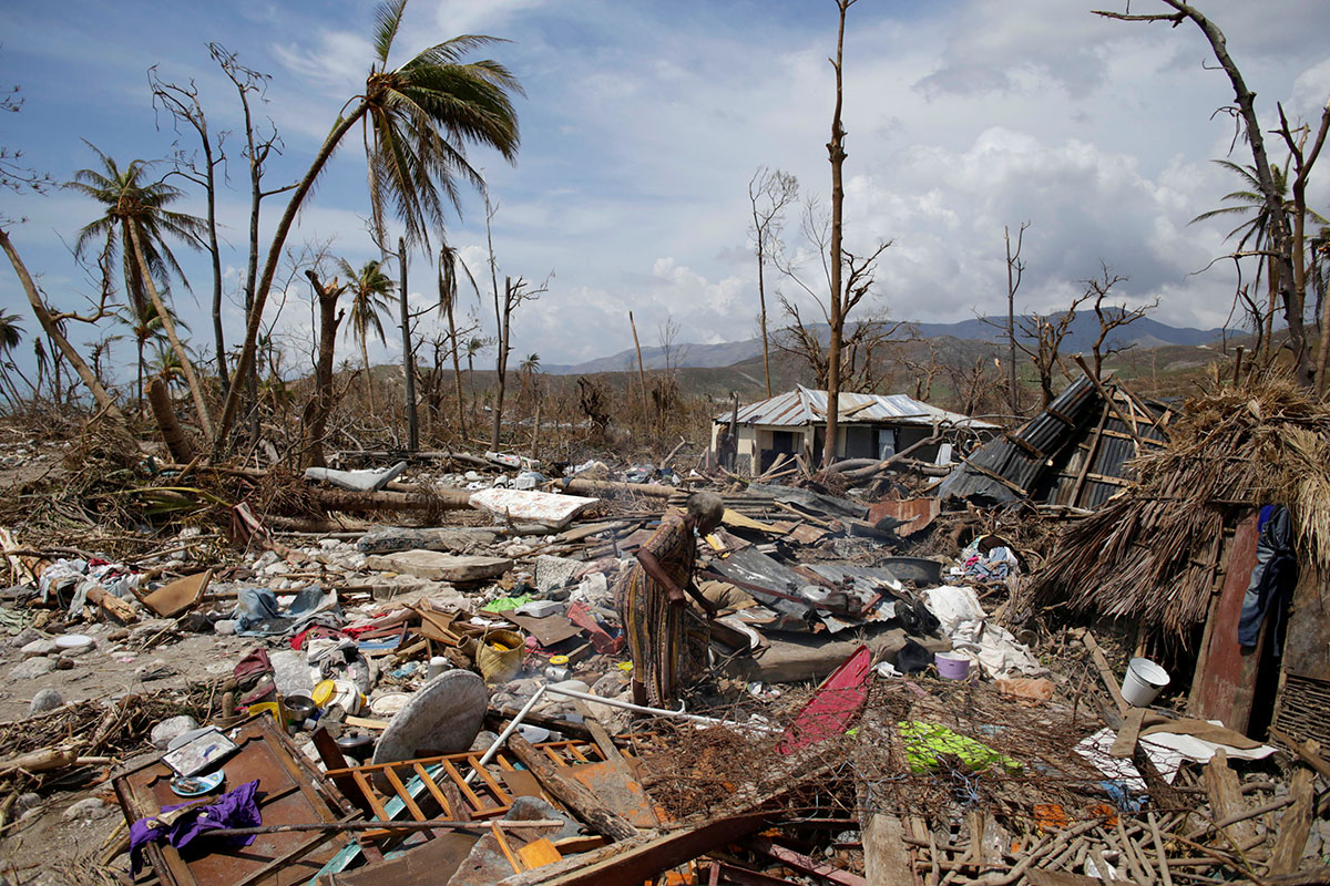 A woman walks on debris in an area devastated by Hurricane Matthew in Port-a-Piment, Haiti