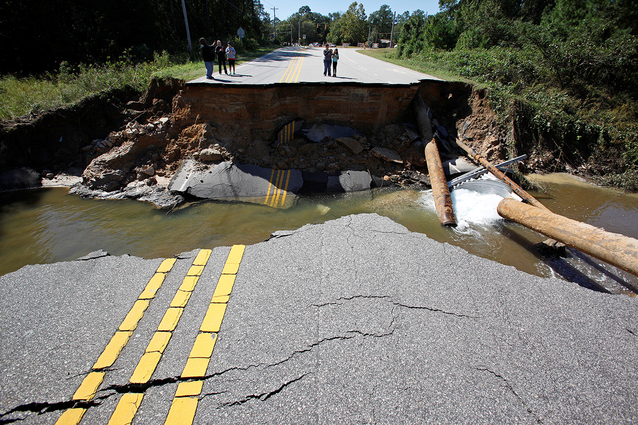 Residents inspect a washed-out section of collapsed road after Hurricane Matthew hit the state, in Fayetteville, North Carolina