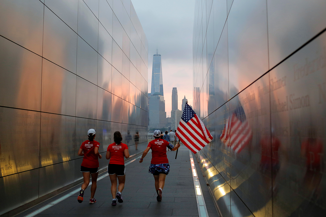 People run through the Empty Sky memorial at daybreak over lower Manhattan on the morning of the 15th anniversary of the 9/11 attacks, in New Jersey