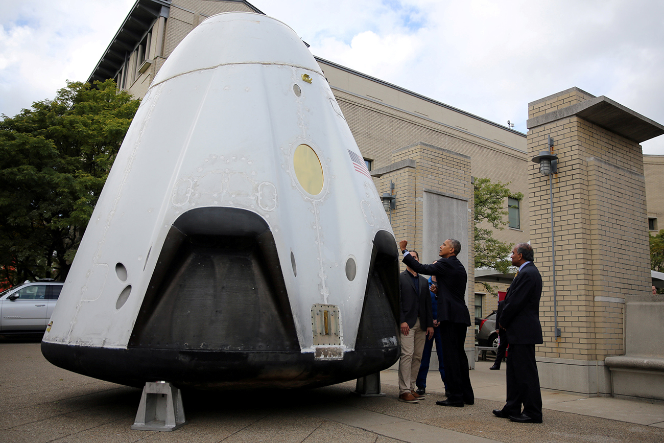 U.S. President Barack Obama stands next to a space capsule during a tour of the innovation projects at the White House Frontiers conference in Pittsburgh, U.S. 
