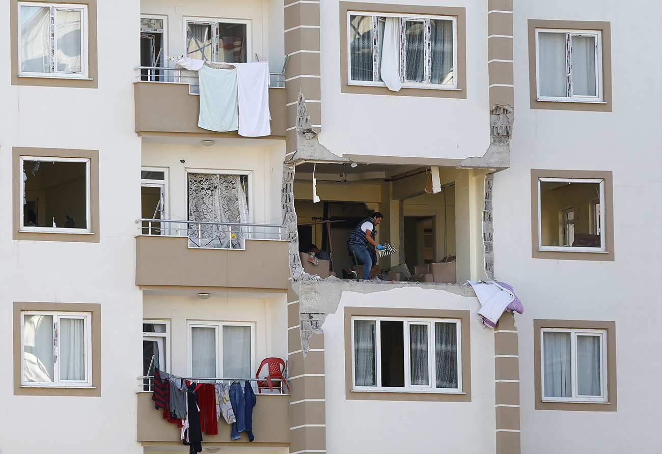 A police forensic expert examines an apartment after a blast in the southeastern city of Gaziantep, Turkey