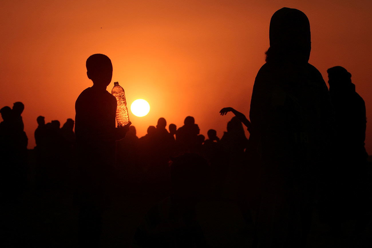 Iraqis who fled violence in Mosul gather as they reach Syria, near the Iraqi border, in Hasaka Governorate 