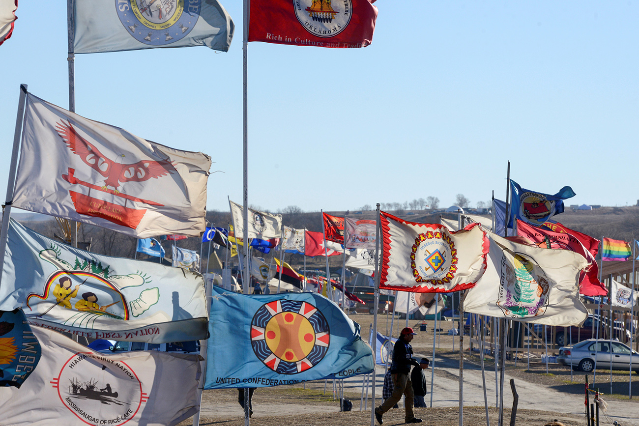 A person walks past the flags of many Indian Nations in the Oceti Sakowin camp during a protest against the Dakota Access pipeline near the Standing Rock Indian Reservation near Cannon Ball, North Dakota